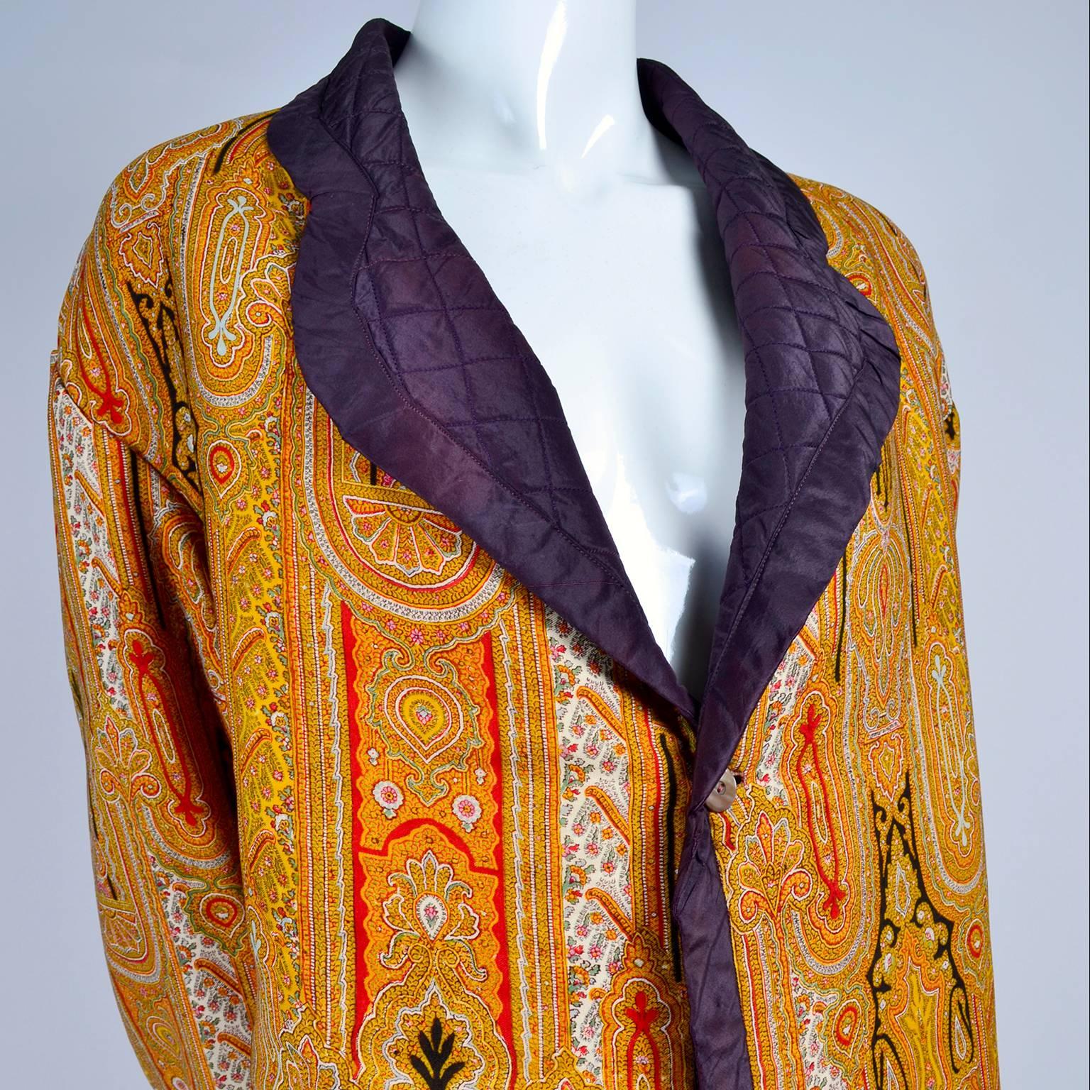 This is a beautiful vintage coat with Moroccan designs in gold, orange, red and black. It is lined with quilted purple fabric that shows on the collar as well as the cuffs. It has one mother of pearl button closure in front. The button is on the