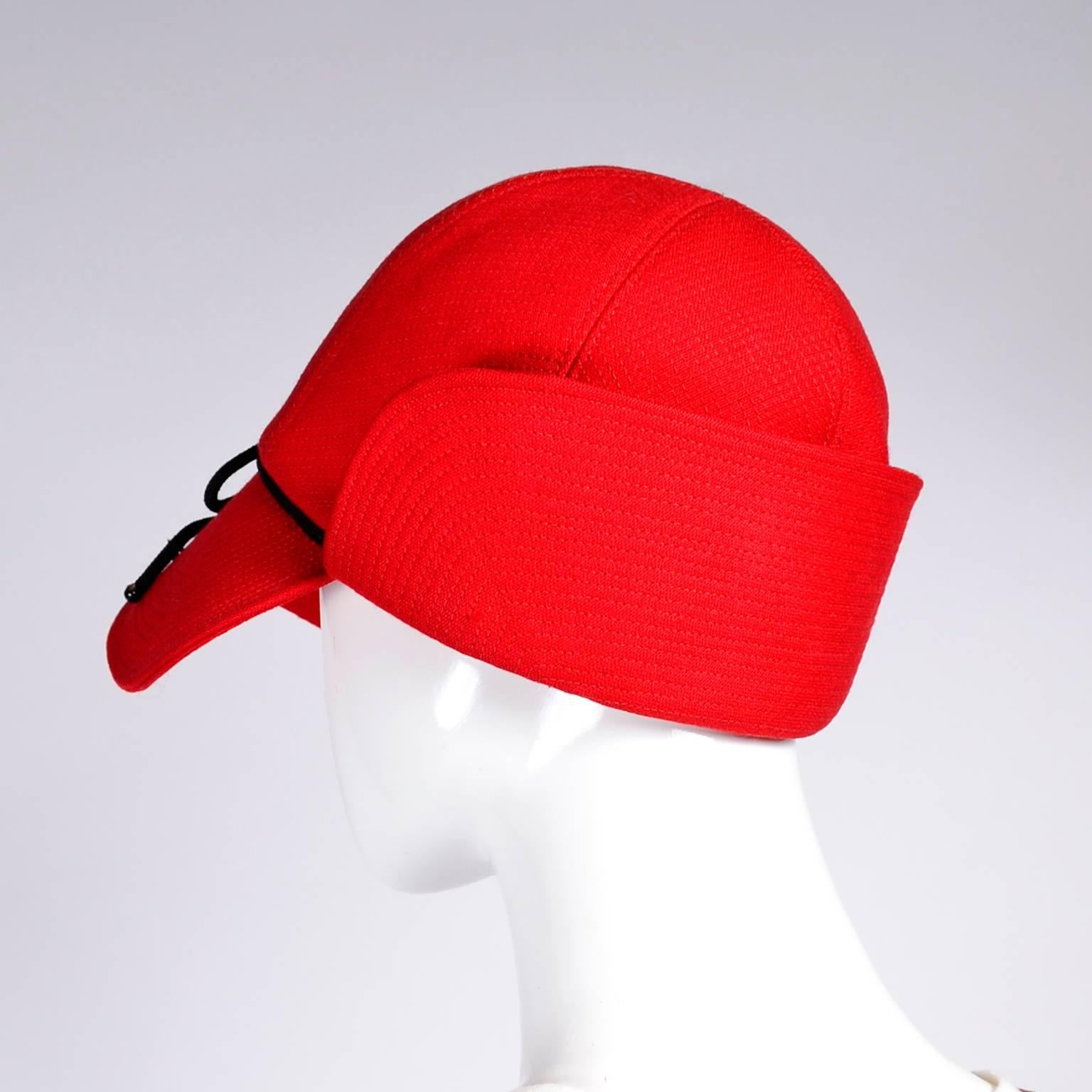 This is a wonderful vintage YSL red flap cap with top stitching and black trim. The hat measures 22” in circumference on the inside rim and is labeled a size small. This hat is lined in red satin and is an unusual style - similar to a dear stalker