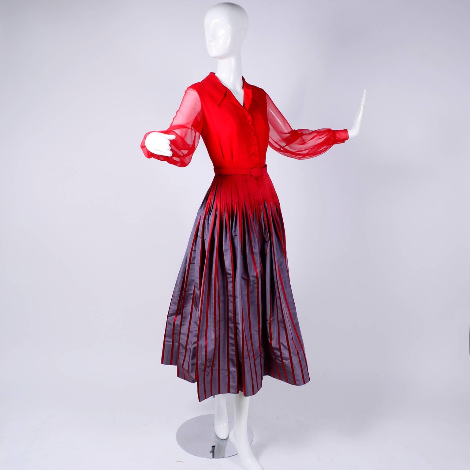 This gorgeous vintage Jean Louis dress has a red chiffon lined bodice with unlined sheer full cuffed sleeves, and a full pleated red and gray striped taffeta skirt. The dress has its original red fabric belt , which is stamped with Jean Louis, and