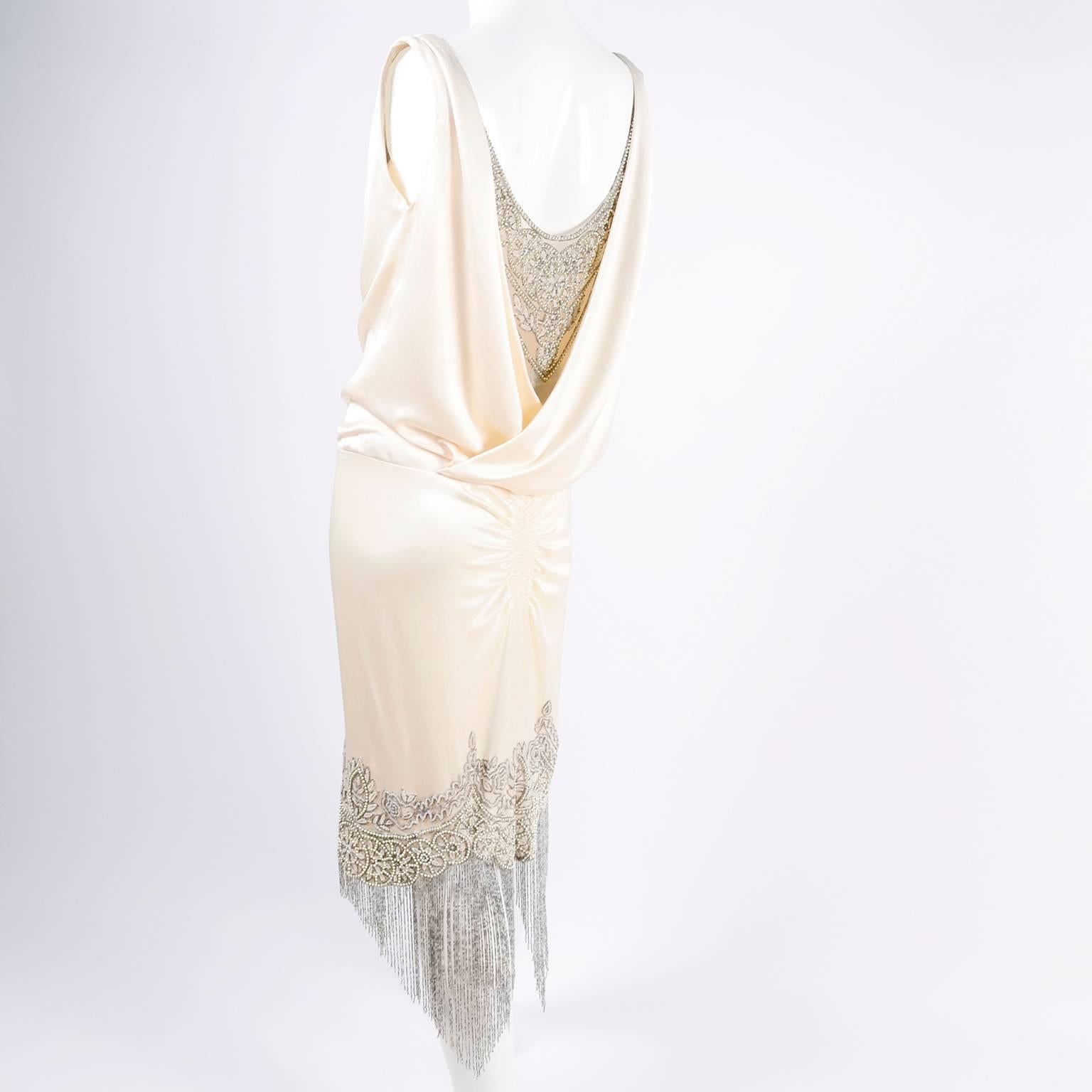 This is an exquisite creamy ivory silk dress designed by Alexander McQueen with exceptional hand beading.  Marked 2007, the silk charmeuse drapes at the neckline over a nude tulle net underlayer that is embellished with bugle beads, rhinestones,