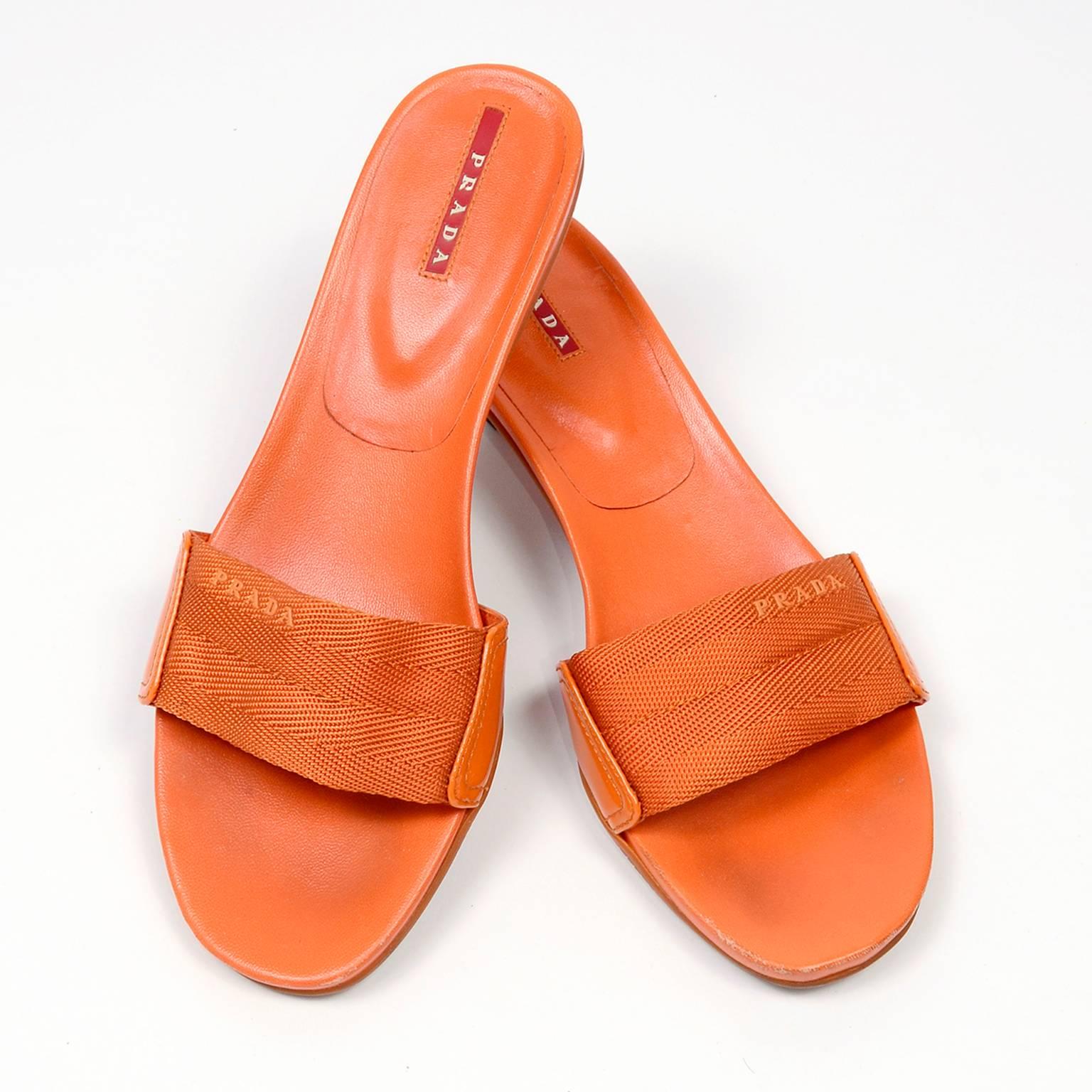 These are great Prada Summer slip on sandals in orange with PRADA on the fabric webbing band with patent leather on the side and 2