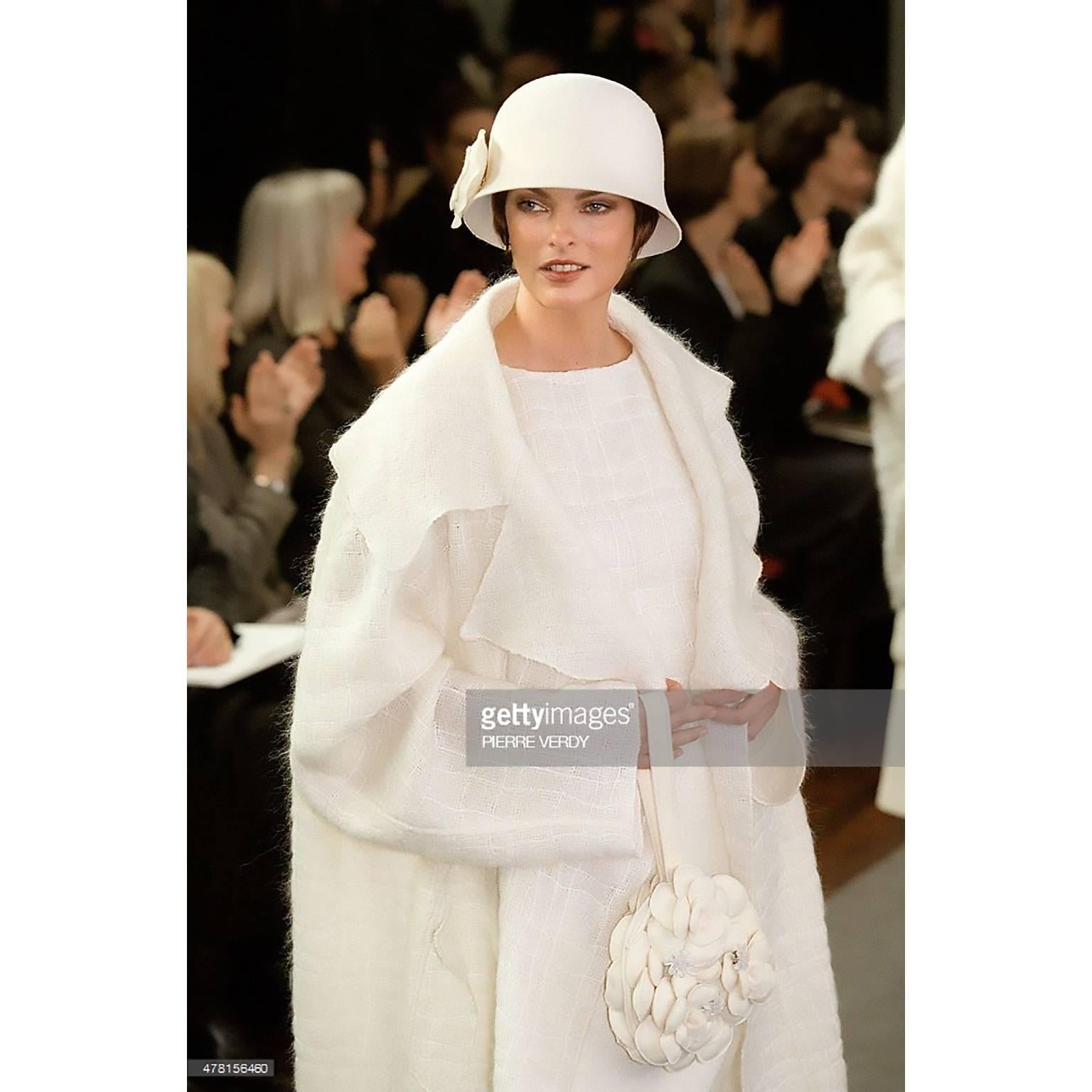 This Chanel coat is from Chanel's Autumn Winter 1998 collection and the same style was modeled by Linda Evangelista on the runway. The coat is loosely woven in a cream wool and mohair blend and because it has such an airy, lightweight feel, it would