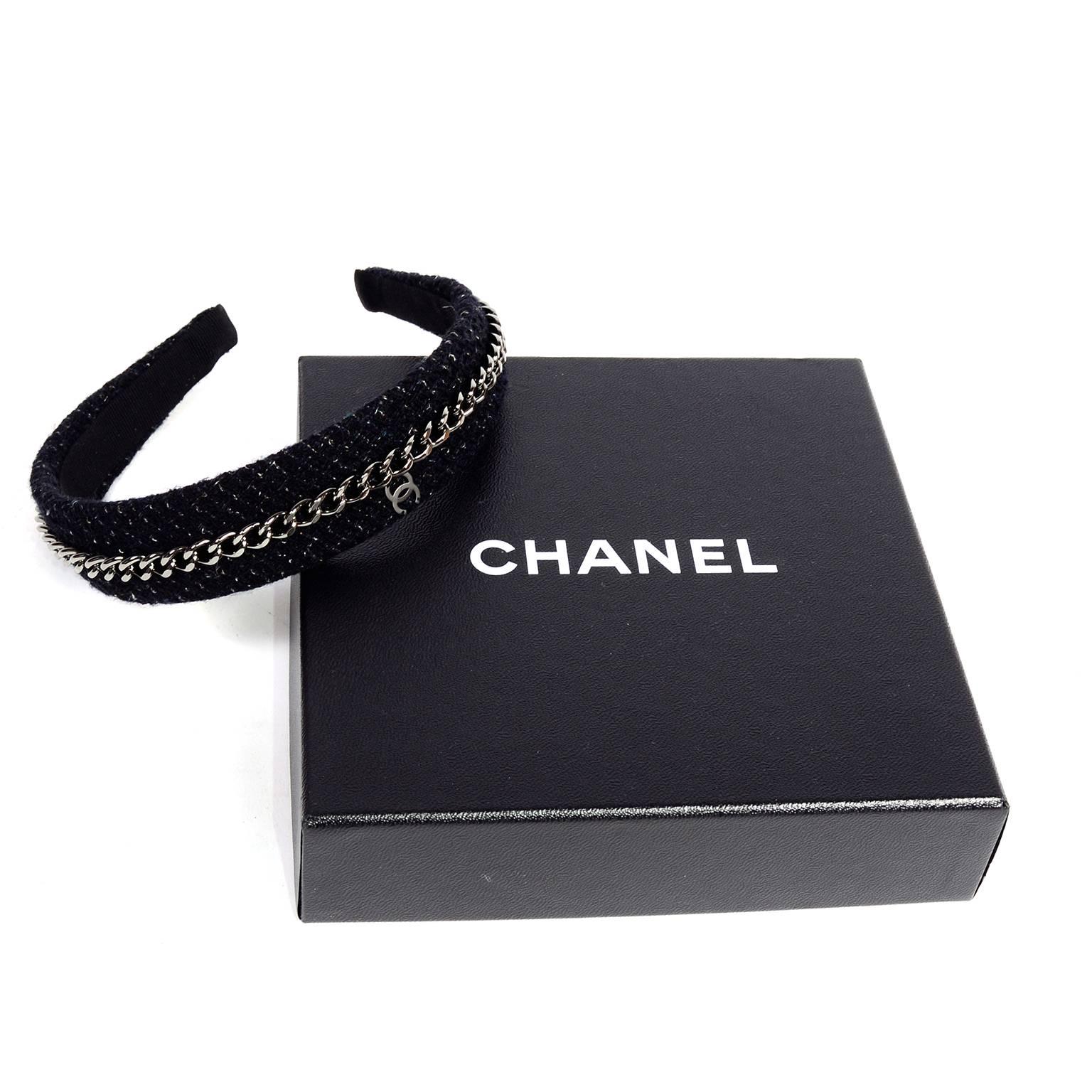 This is a classic Chanel Headband in a gorgeous charcoal and black metallic tweed with a metal chain running the length of the crown and a CC monogram metal logo.  The headband comes in its original box and appears unworn. What a great way to wear a
