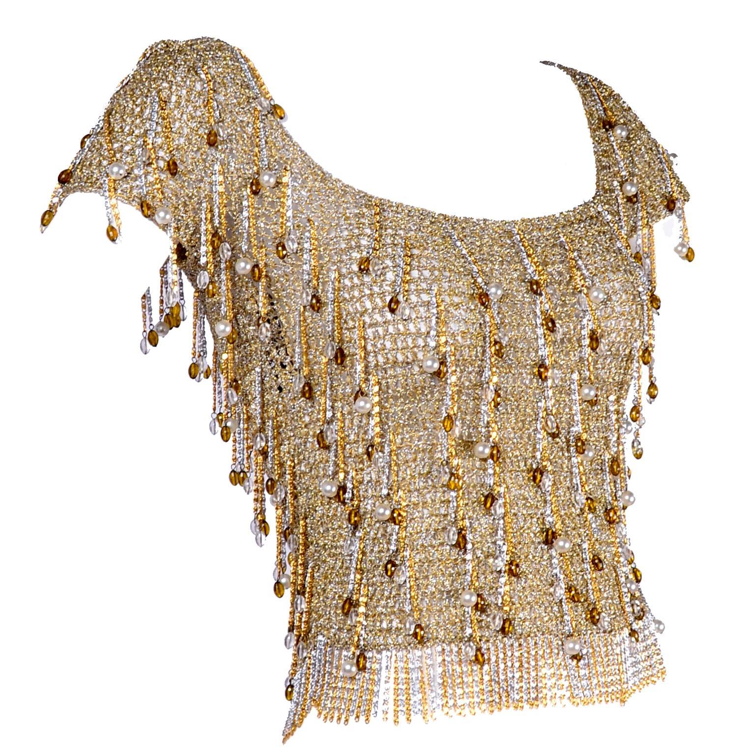 This is an absolutely  gorgeous 1970s silver and gold metallic lurex crochet top from Loris Azzaro.  This vintage short sleeve top has metal chain fringe and amber and clear beads as well as faux pearls. The top has quite a bit of stretch and is 19