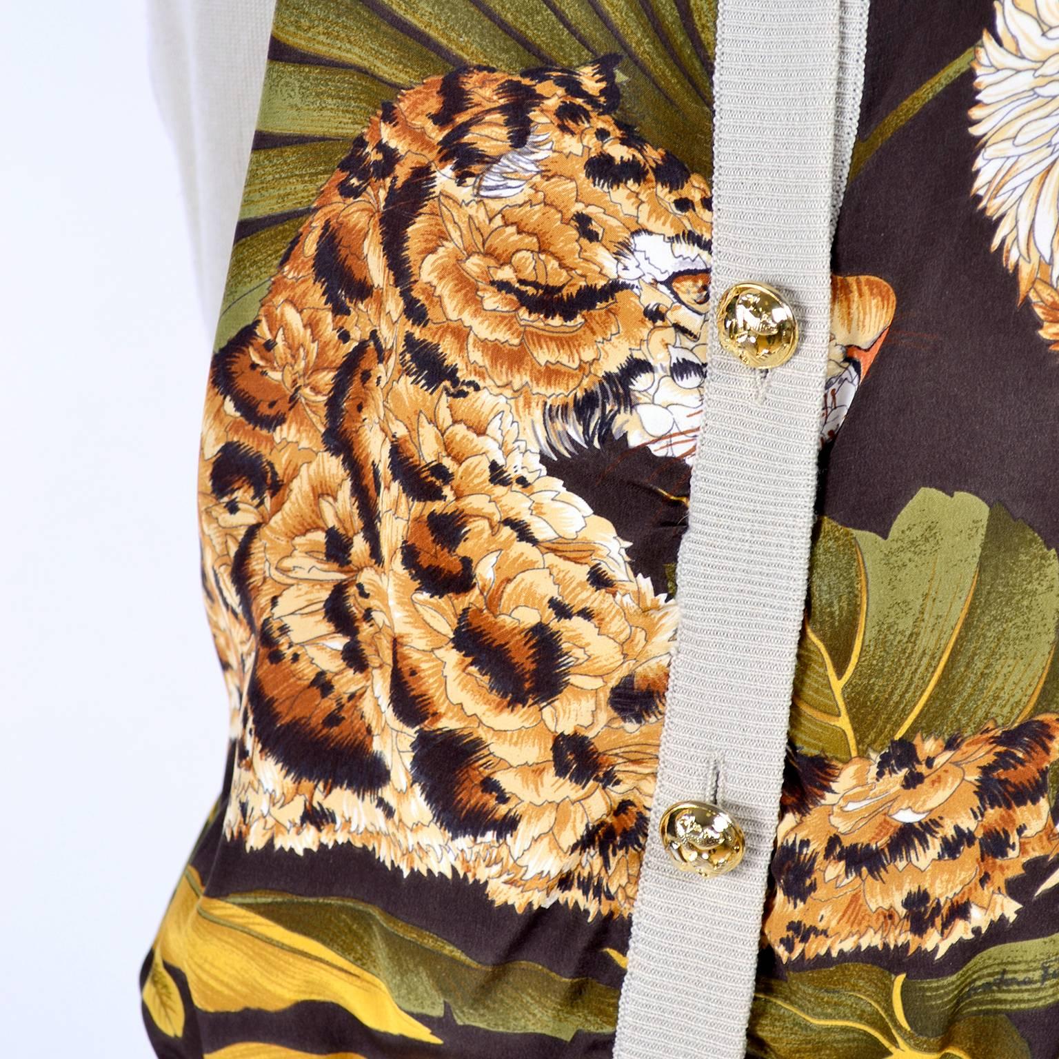 This vintage Salvatore Ferragamo cardigan sweater has front panels of printed silk in a tropical scarf print that includes leaves, bamboo and abstract animals with pale taupe knit fabric back, sleeves and trim. We have had several of these Ferragamo
