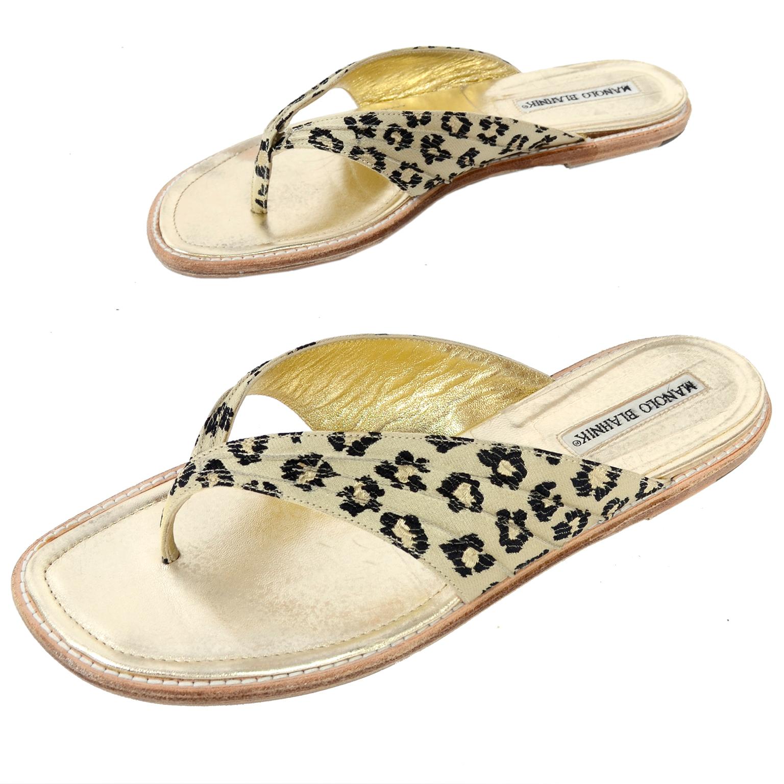 These vintage Manolo Blahnik sandals have a cheetah print fabric upper and a gold leather base. These shoes have had a rubber protective sole added atop the original leather sole. The inside sole shows some rubbing to the gold. Fits like a women's 8