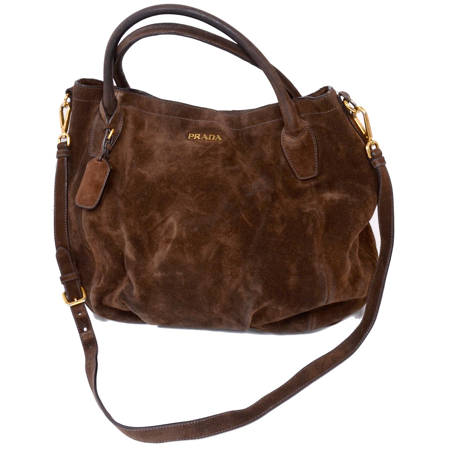 This is a large Prada brown suede slouchy shoulder bag with two top handles and a removable adjustable shoulder strap. All the gold hardware is marked 