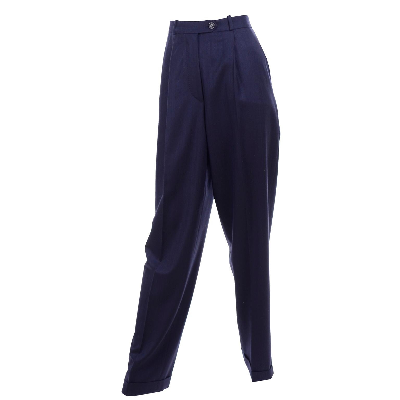 These are timeless vintage Hermes trousers in fine navy blue lightweight wool with front pleats, cuffs, and side slit pockets. These high waisted pants have belt loops and close with a front zipper and a single button.  These are labeled a size 38. 