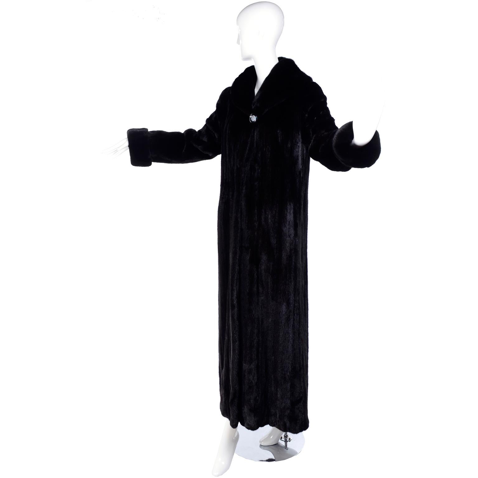 This is a beautiful, fully lined Blackglama dark ranch raised mink coat with black velvet lined side slit pockets. This full length, almost black coat closes with 2 front hooks and eyes and fits a size 6/8. .We acquired this coat from an estate we