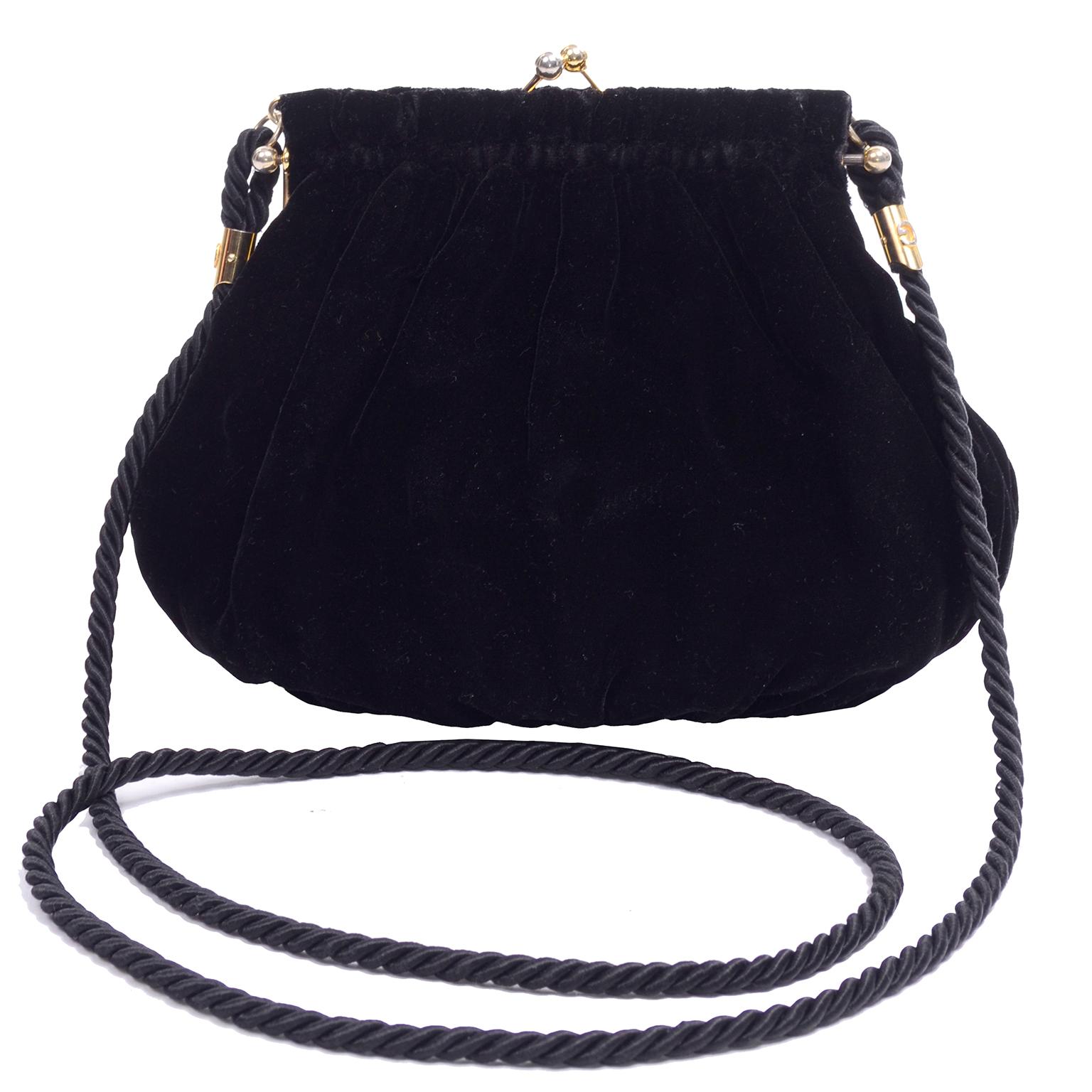 This is a lovely vintage handbag with a twisted rope shoulder strap from Gucci. The bag is in a luxurious black velvet and closes with a top kiss clasp.  There are two interior side pockets and the bag appears to have been only used once or twice at