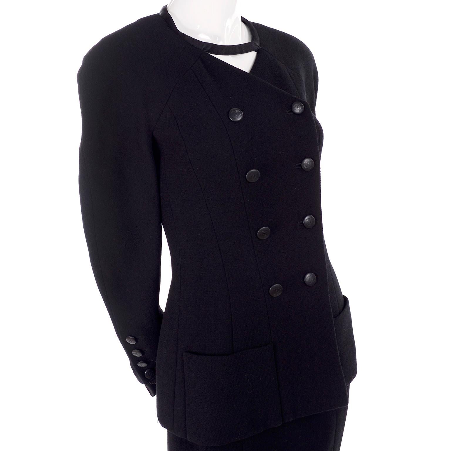 This is a wonderful vintage black wool Chanel suit designed by Karl Lagerfeld for the 1996 Cruise / Resort collection. The outfit includes a skirt and a double breasted jacket with an interesting connecting piece of fabric that crosses over at the