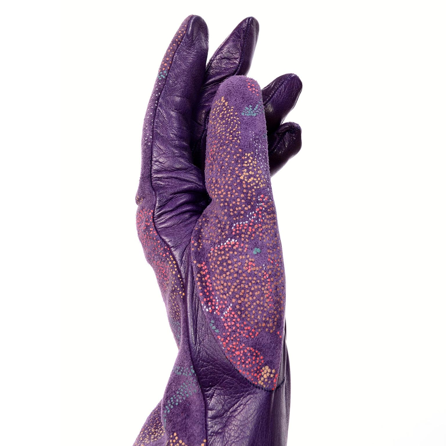 Diese atemberaubenden Vintage-Lederhandschuhe wurden von Carlos Falchi entworfen und in Italien hergestellt. Die Handschuhe sind aus lila Leder mit handgemalten Blumen im Pointillismus-Stil in Lila, Rot, Gelb, Weiß und Blau auf der Oberseite. Diese