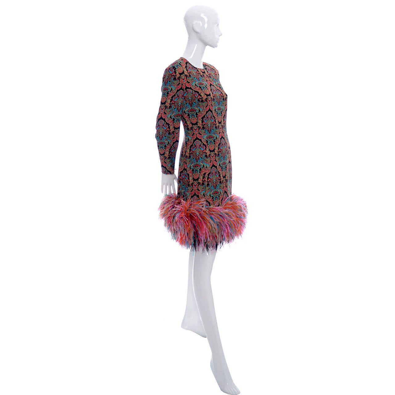 This James Galanos 1980s vintage cocktail party dress has sensational bright, multi colored ostrich feathers around the hem.  The dress is in excellent  condition with 3 ½” zippers on the sleeves and almost a foot of feathers at the hem. Fabric