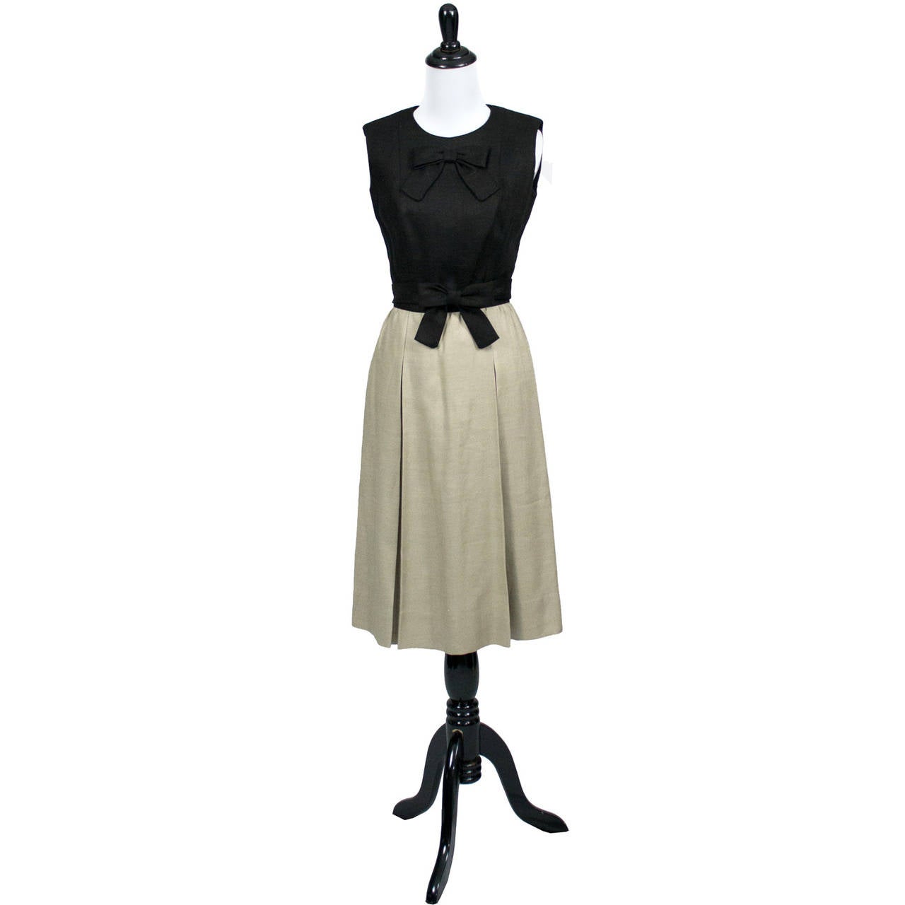 A rare vintage 1960's linen two toned sleeveless dress in mint condition from designer Donald Brooks. This classic vintage dress has a black bodice and taupe linen skirt with original fabric belt and a pretty bow at the waist. There is a back zipper