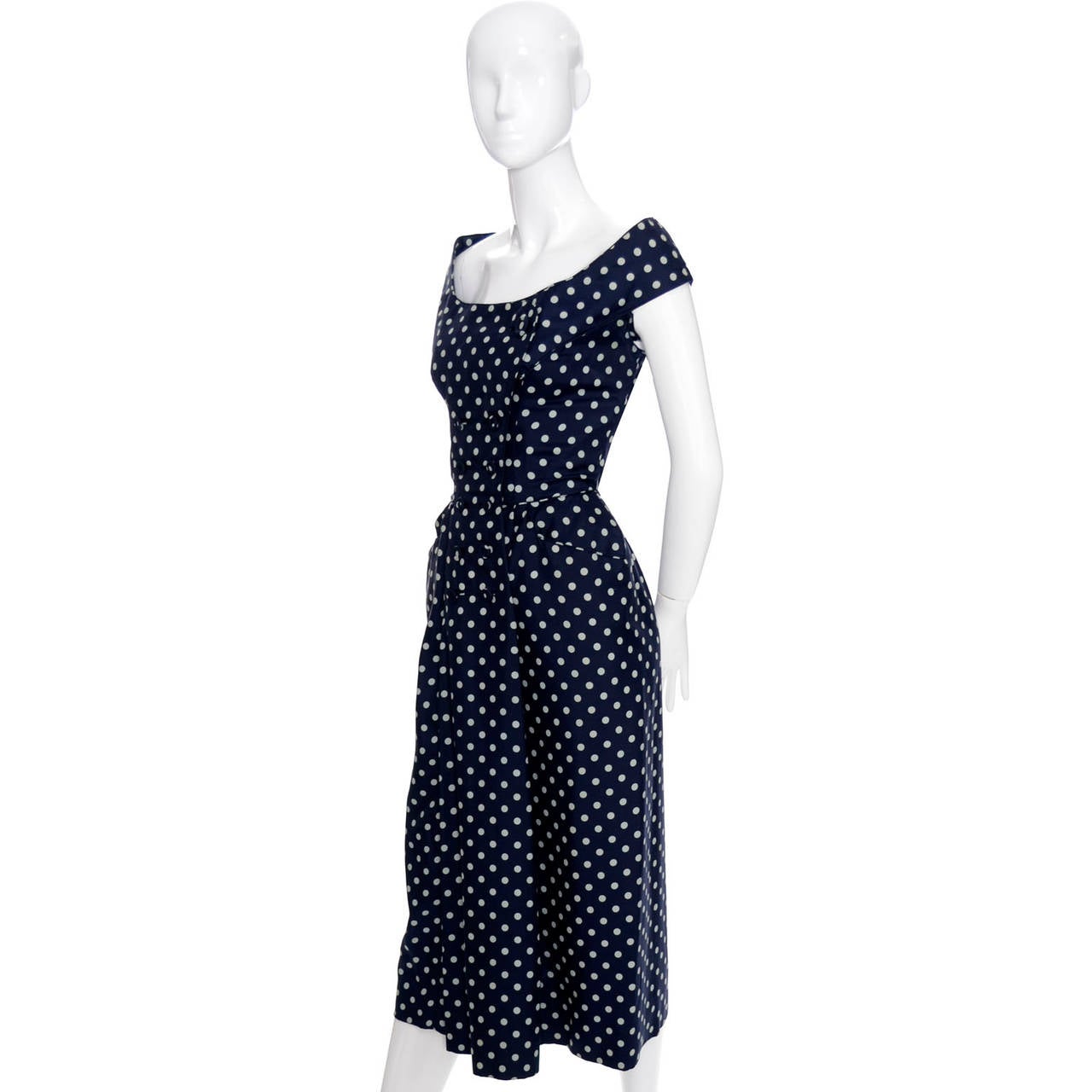 This outstanding vintage dress is from the 1950s and was designed by Ceil Chapman.  This incredible dress in in excellent condition with a slightly off shoulder neckline, double breasted bodice with fabric covered buttons, really nice piping detail,