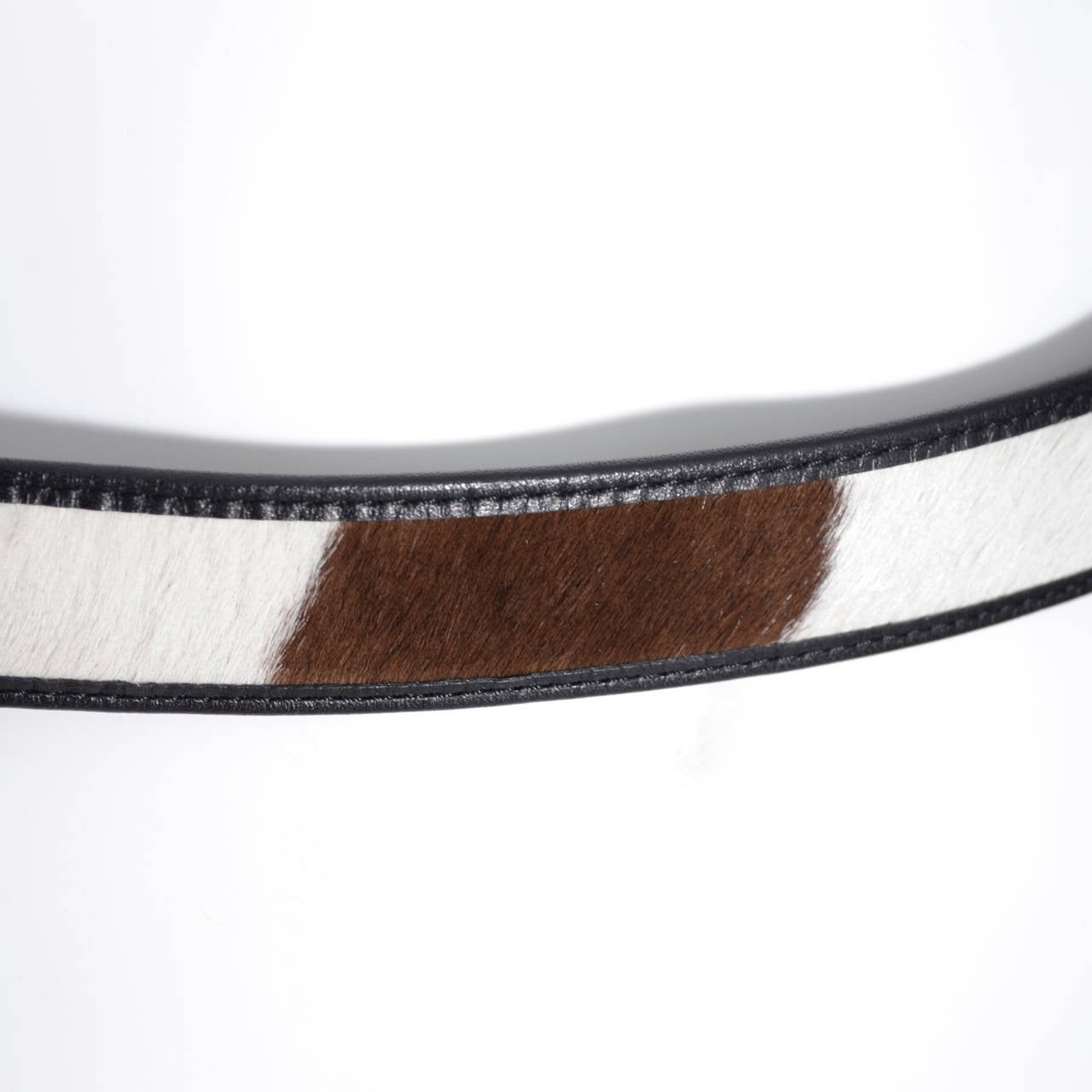 Vintage Comme des Garcons Belt in brown and white cow fur
on black leather from Comme des Garcons.  The belt is 1 inch wide and fits 26-33