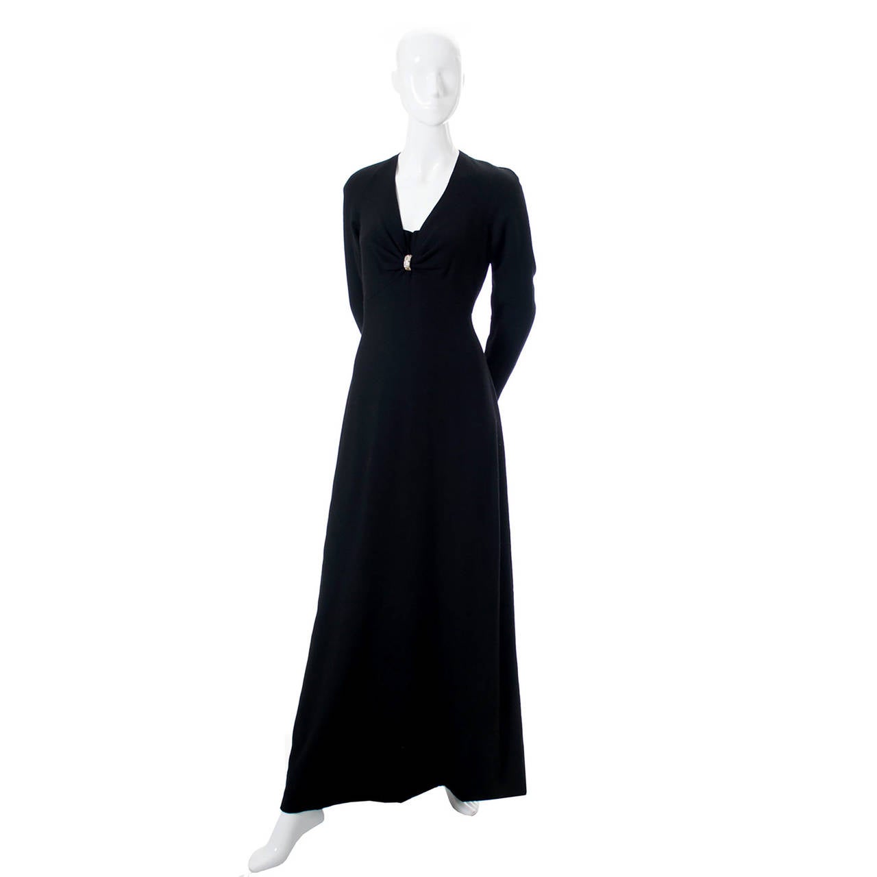 This is a vintage 1970s full length black wool crepe knit designer dress from Nina Ricci designed by Gerard Pipart. The dress has a pretty rhinestone accent piece on the bodice, nice covered buttons on sleeves, a back zipper, and a beautiful fit.