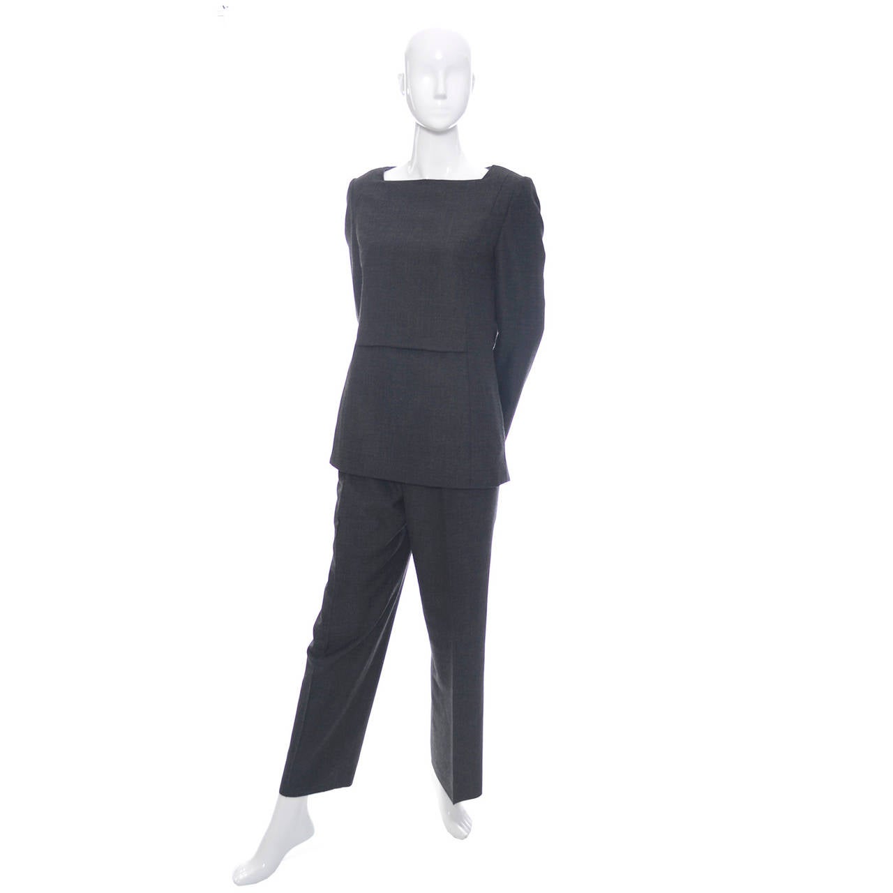 This is a classic lightweight gray wool 2 piece vintage pantsuit outfit from James Galanos. The top is a tunic with long sleeves and front pockets and the pants have side slit pockets and a side zipper. This outfit is lined and is in excellent