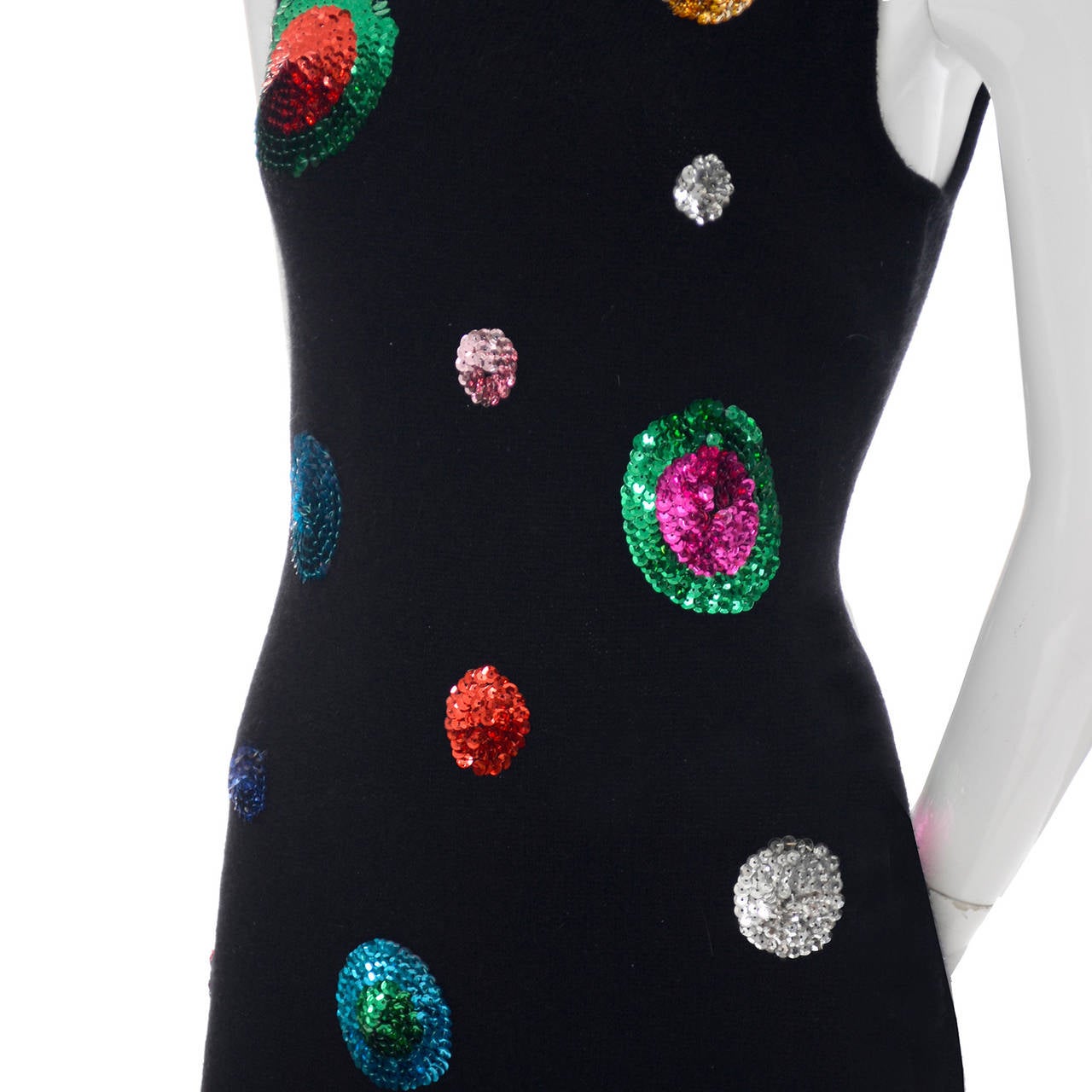 This vintage Adrienne Vittadini dress still has its original tags. The dress is black with beautiful multi colored sequin circles all over.  There is a back zipper and the dress is made of 75% lambswool, 15% angora and 10% nylon.  The dress