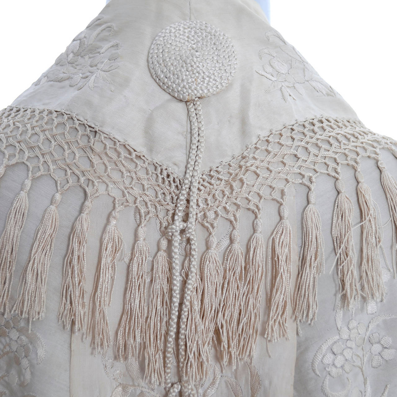 This exceptional ivory silk embroidered wrap has luxurious fringe and tassels. The embroidery is spectacular and the shawl would make a beautiful wrap for a bride.  This piece comes from the estate of a woman who collected vintage clothing and