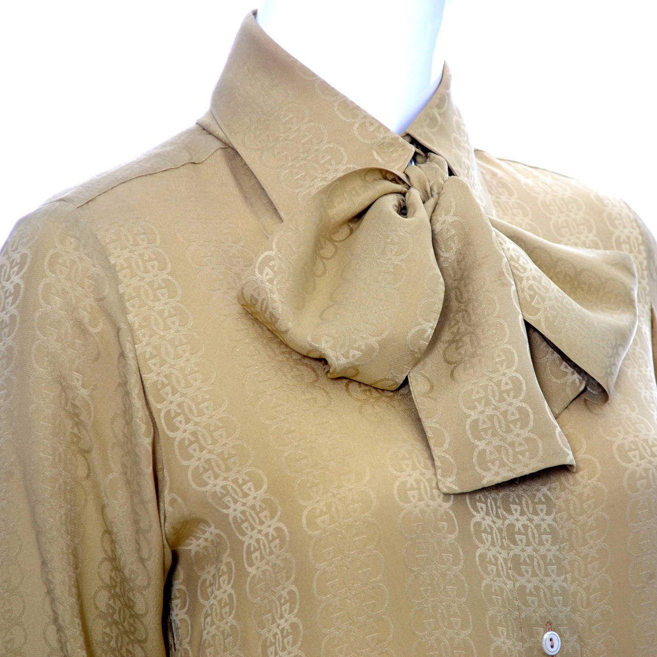 This is a lovely vintage silk blouse from Gucci made in the 1970's. Pretty gold silk logo fabric with buttons up the front and a separate sash that can be tied in a knot or a bow.  The blouse is in excellent condition and was made in Italy. I would