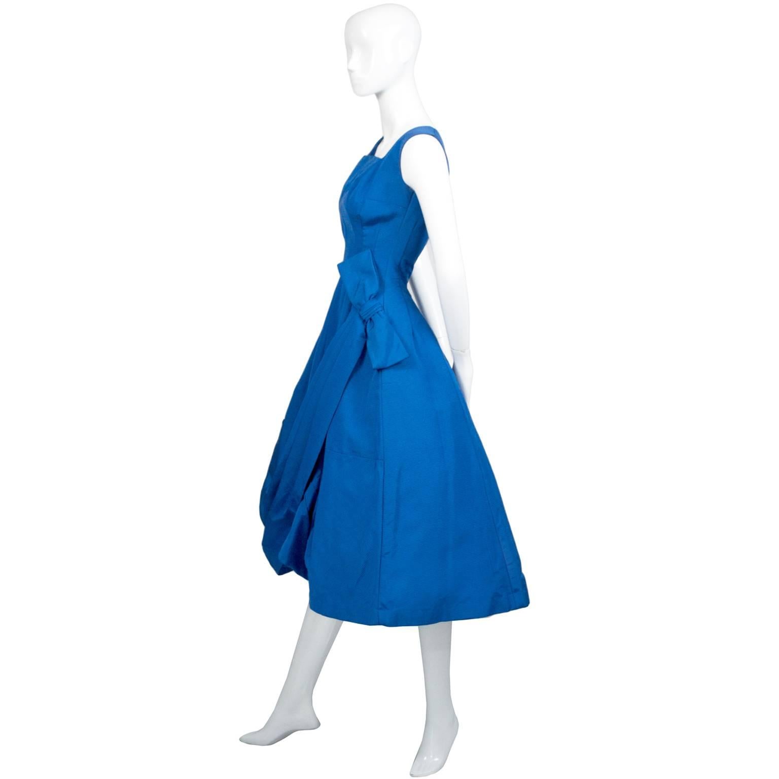 This is an exceptional vintage 1950s dress. This micro ribbed blue party dress has a pretty side bow and wonderful draping in the front.  This 50's dress is so beautifully made and appears to be a designer piece, but there are no labels found.  This