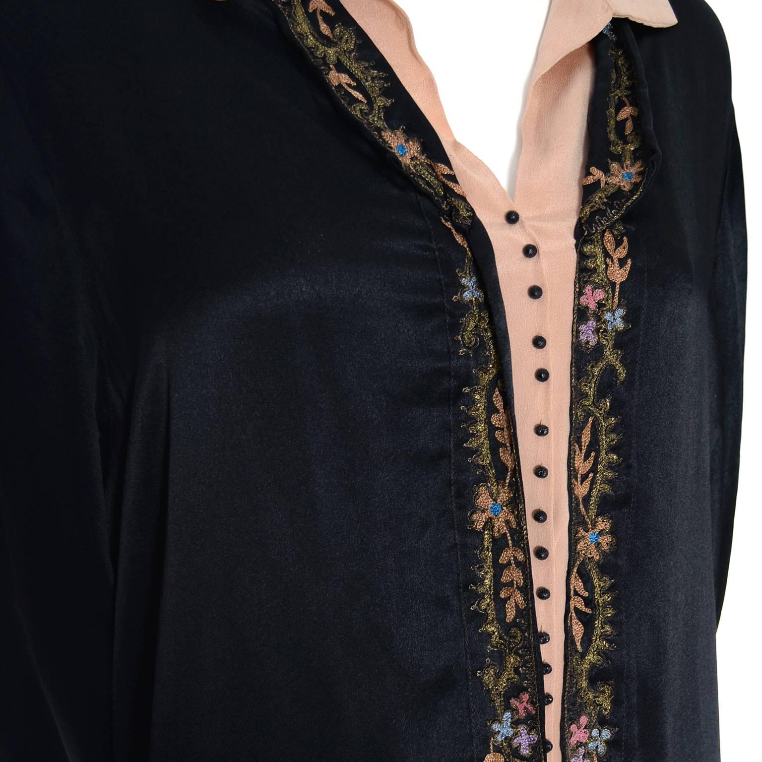 This is a lovely vintage larger size 1920's black silk dress with gorgeous fine floral embroidery and inset pale peachy pink silk fabric with tiny black buttons.  The skirt of this 20s drop waist dress is beautifully pleated and the fabric belt has