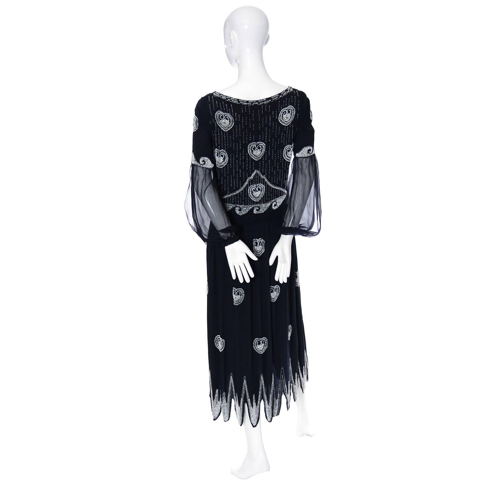 This is an outstanding vintage 1920's dress with original sash and gorgeous white beadwork.  The dress has a slight drop waist, handkerchief hemline and hooks and eyes up the side.  The beautiful sleeves are split to expose a little flesh and snap