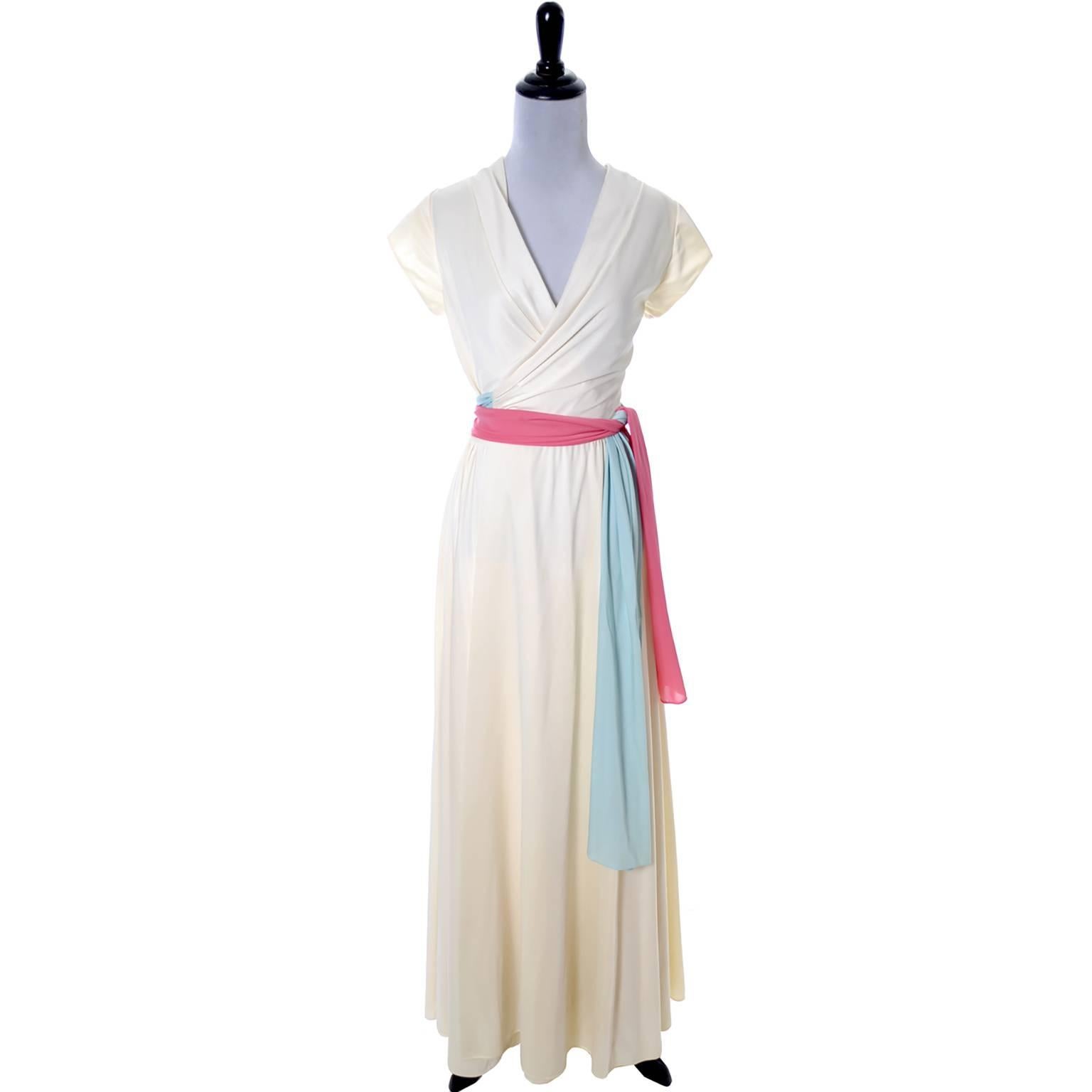 This is a lovely vintage late 1950's ivory hostess gown from Lucie Ann of Beverly Hills. This luxurious full length wrap gown has pretty sashes in shades of pink and blue and could easily be worn as an evening gown because of the weight of the
