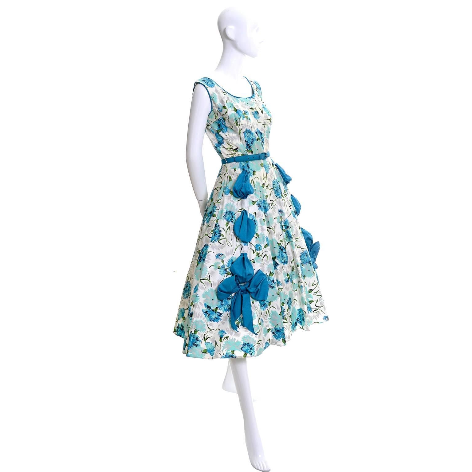 This is a fabulous 1950's vintage party dress with gorgeous rhinestones and beautiful wide blue ribbons that are threaded through the skirt of the dress and tied in bows at the end.  The sleeveless vintage 50's dress has a side metal zipper and its