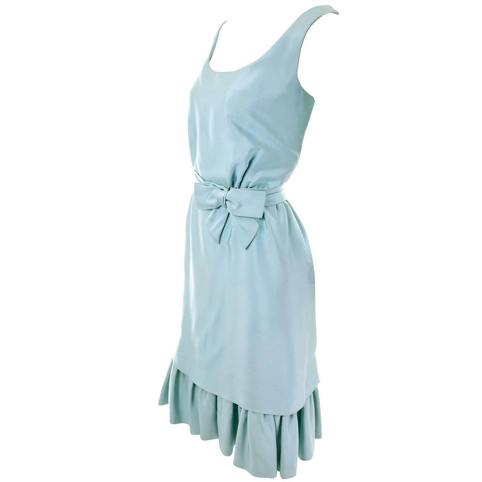 This is a stunning blue green vintage Jobere cocktail dress from the 1960's. The dress has a low back with a zipper and a fabric belt with a side front bow.  We love the ruffle at the bottom that is actually the bottom of an attached 