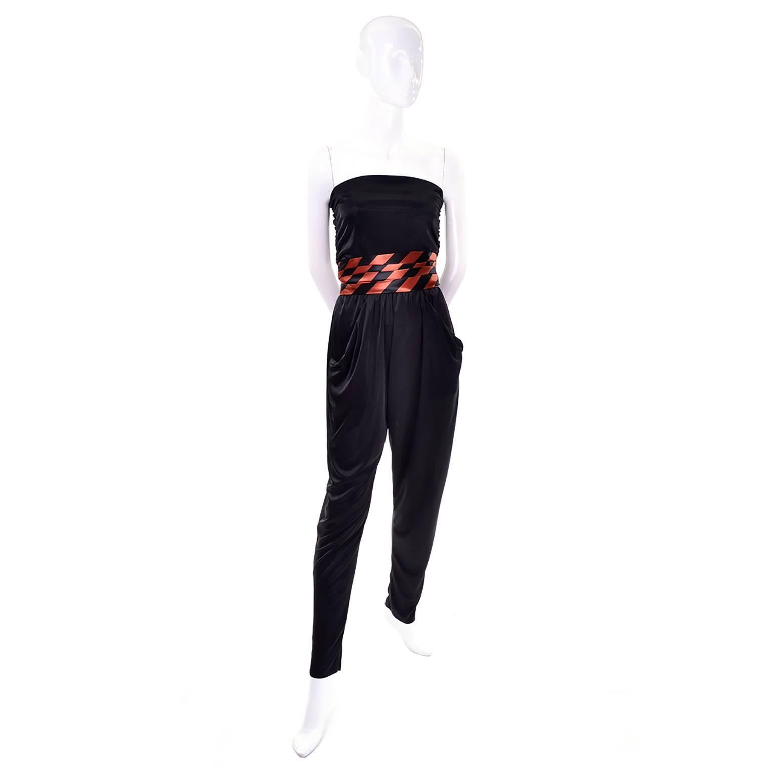 This 1970's vintage jumpsuit with a coordinating orange and black satin striped jacket and cummerbund is perfect for any Halloween or Fall party! The slinky black jersey jumpsuit is strapless with an elastic waist and slips on with no closures. The