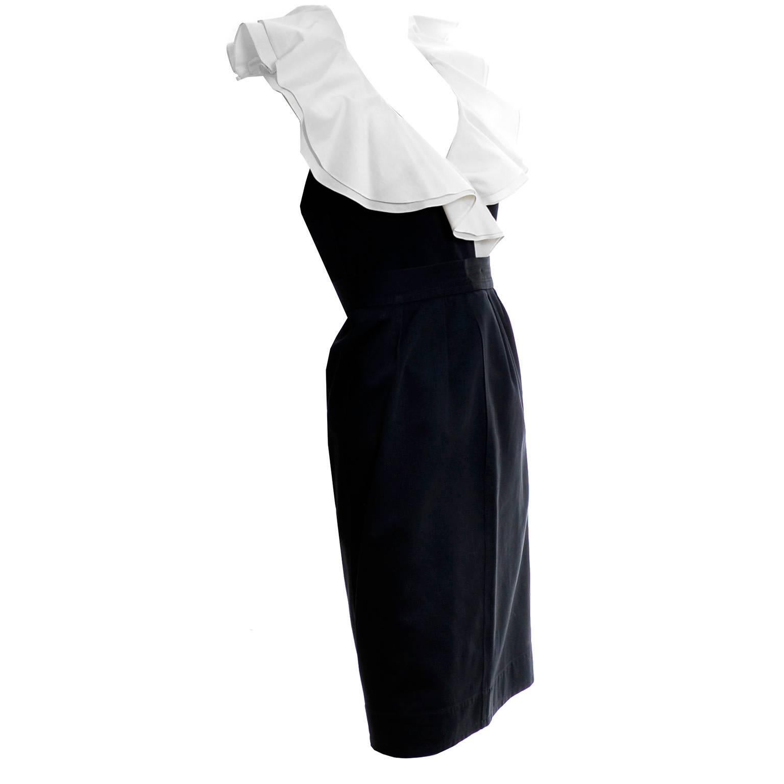 This is a black cotton 2 PC YSL dress has a pretty double layer of white ruffles at the collar. This outfit from Yves Saint Laurent has a button front sleeveless top that is labeled a size 36 and a slim skirt with zipper and hook and eye and side