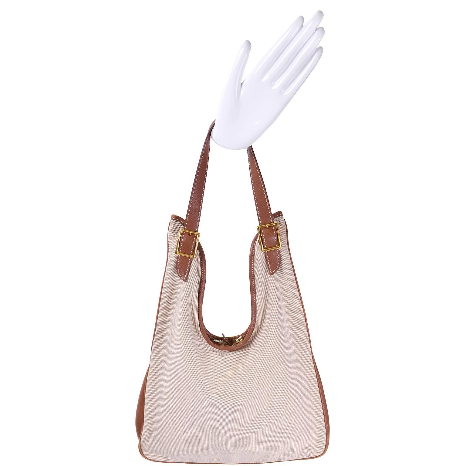 This is a great authentic Hermes France Massai Cut Handbag in beige canvas fabric with brown leather trim and the same fabulous full leather lining. This double zip top hobo style bag has adjustable gold buckles, an inside zip pocket, and it