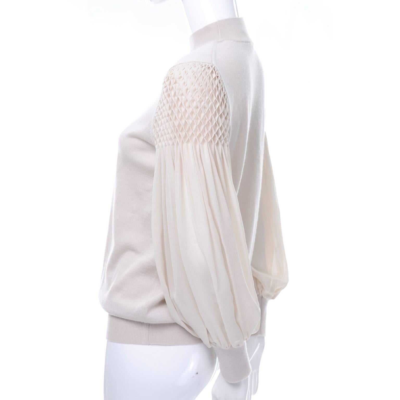 This gorgeous bone or sand colored cashmere sweater is by Luis Vuitton.  The sweater has beautiful puffy silk bishop sleeves that have smocking at the shoulders. There is waffle elastic at the hem, cuff, and neckline. This top was made in Italy and