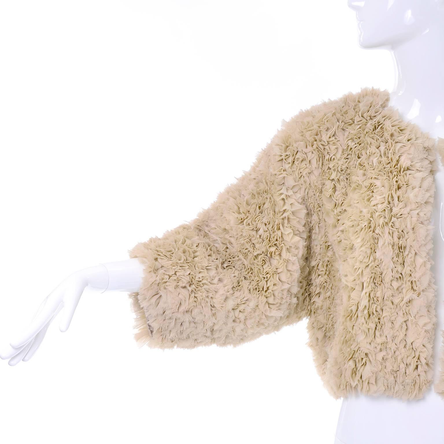 This beautiful vintage Sonia Rykiel jacket is made of raw edged silk ruffles that create a unique texture over the entire piece. This vintage designer jacket is slightly cropped, open in the front, and lined in silk, with raglan 3/4 length sleeves.