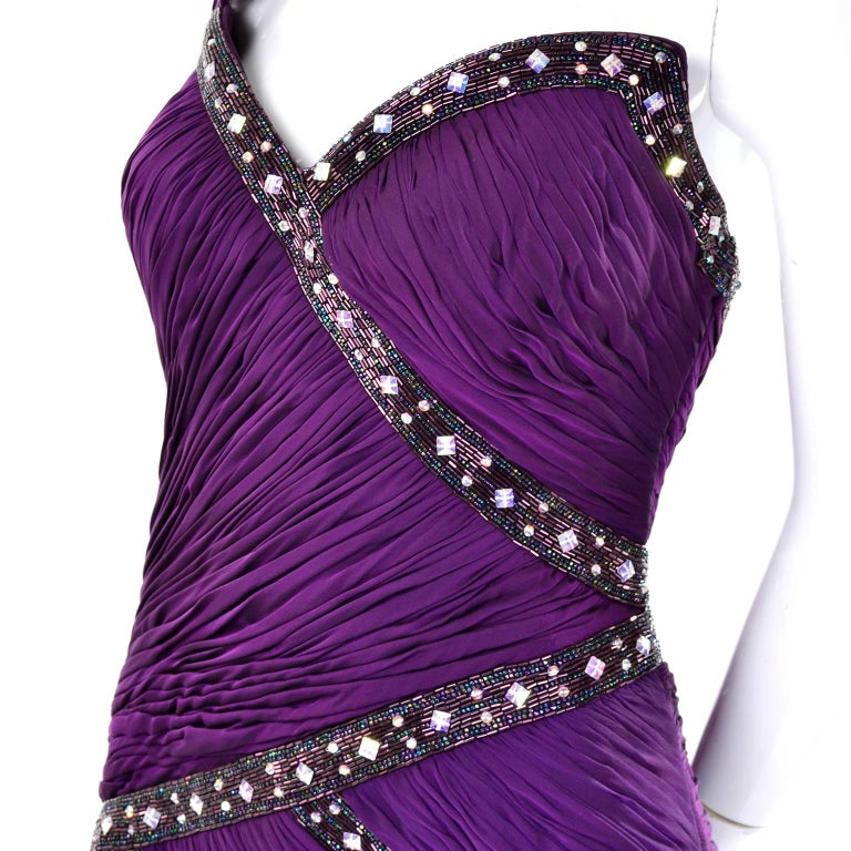 This glamorous purple silk vintage evening gown was designed by Michael Casey in the 1990's.  This beautiful vintage dress has incredible ruching throughout the bodice that ends at the hips.  The full skirt is sheer and flowing and the bodice has