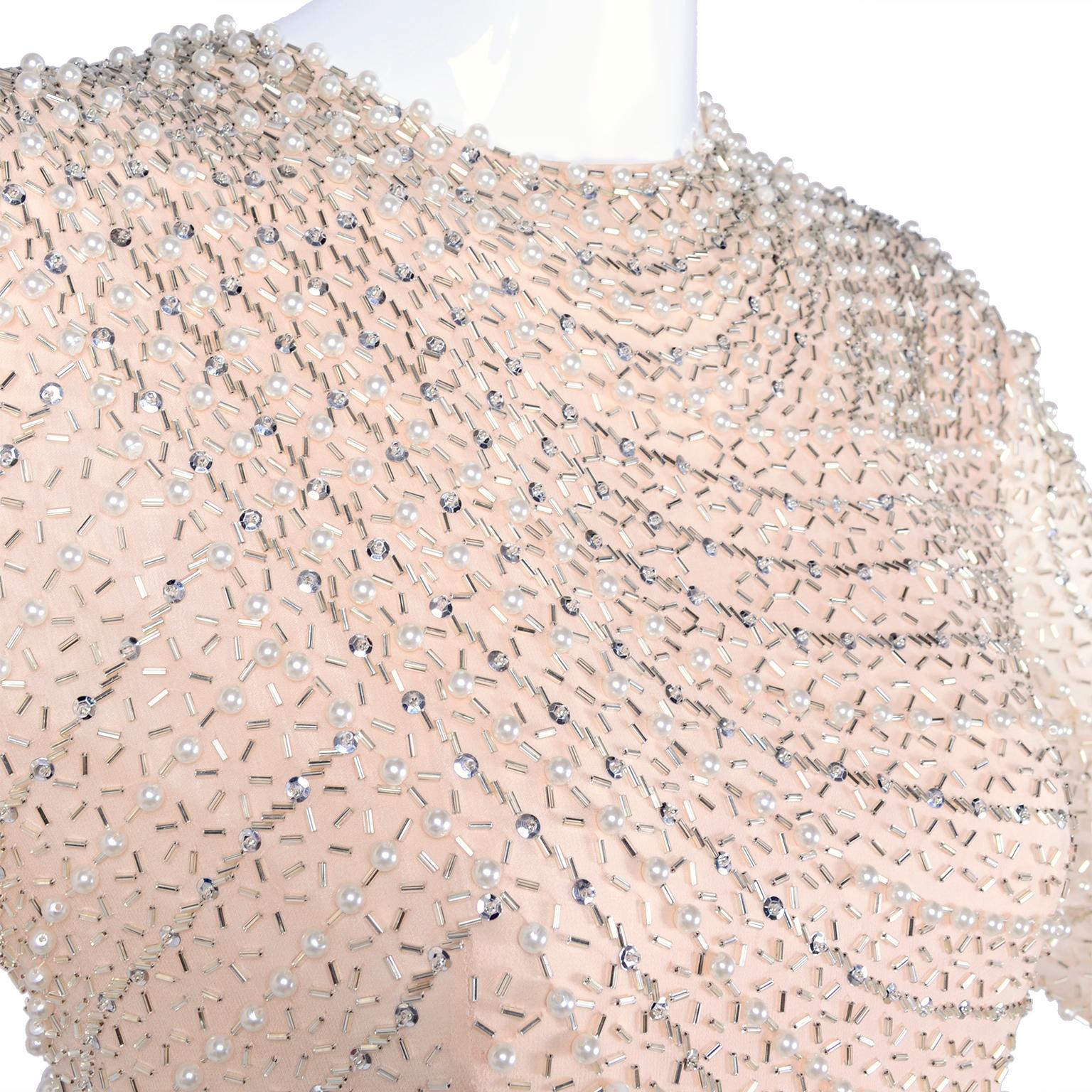This is a lovely pale peachy pink silk dress with mirrored bugle beads, silver sequins and pearls.  The dress has long sleeves, a back zipper, and is fully lined in pink rayon.  The fine silk chiffon is sublime and the dress shimmers beautifully