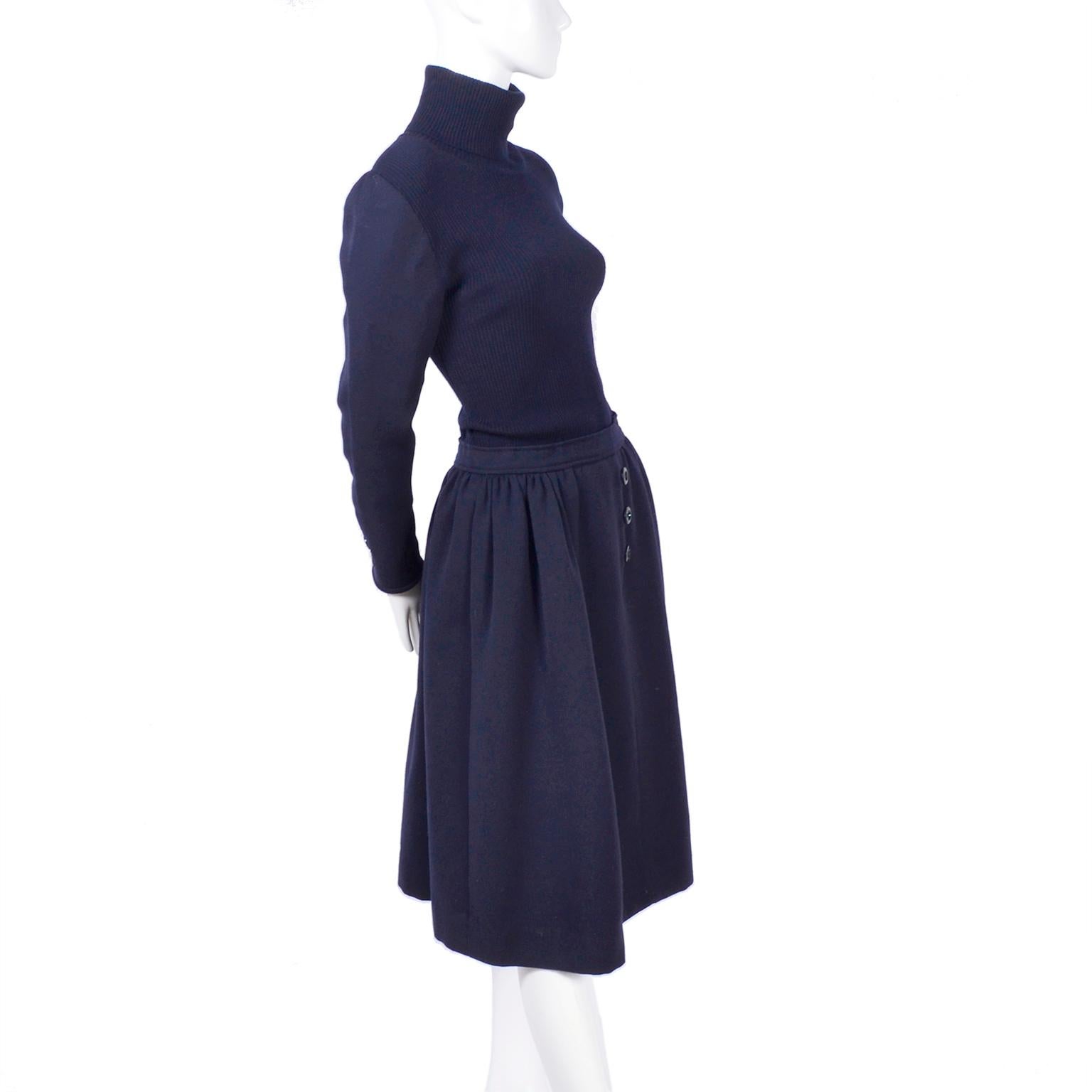 We adore this unique deep navy blue wool Valentino dress suit! This circa 1970's ensemble comes with a dress that has thick wool skirt with three decorative buttons down the front, beautiful pleats, and a waistband that make it look like a separate