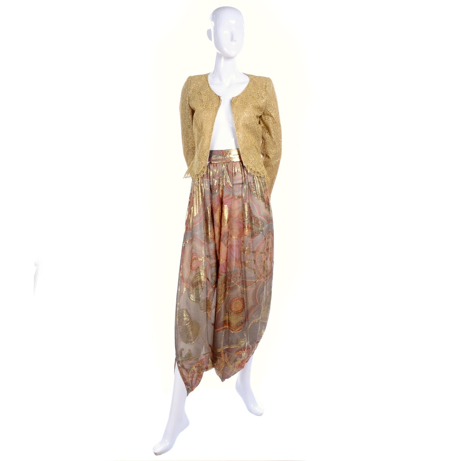 This is such a truly stunning vintage evening ensemble from Mary McFadden Couture. The outfit is a perfect evening dress alternative and includes a pair of silk chiffon harem pants in a grey, pink and peach soft print with gold lame details and a