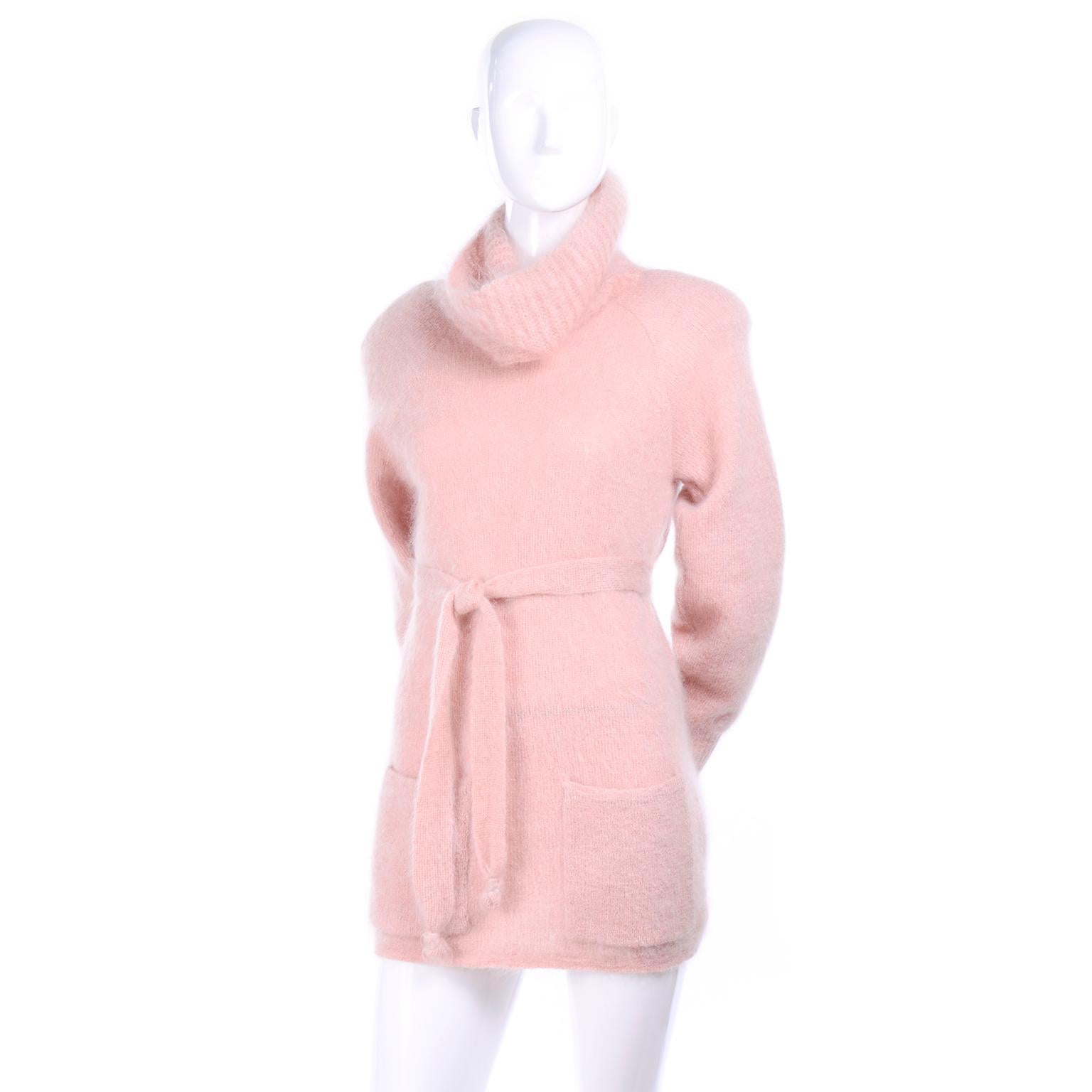 This is a lovely vintage Anne Klein fuzzy pink Sweater with a large cowl neck, belt and front pockets.  The sweater has shoulder pads and is 80% mohair and 20% nylon and was made in Italy in the 1970's. We acquired this sweater from the estate of a