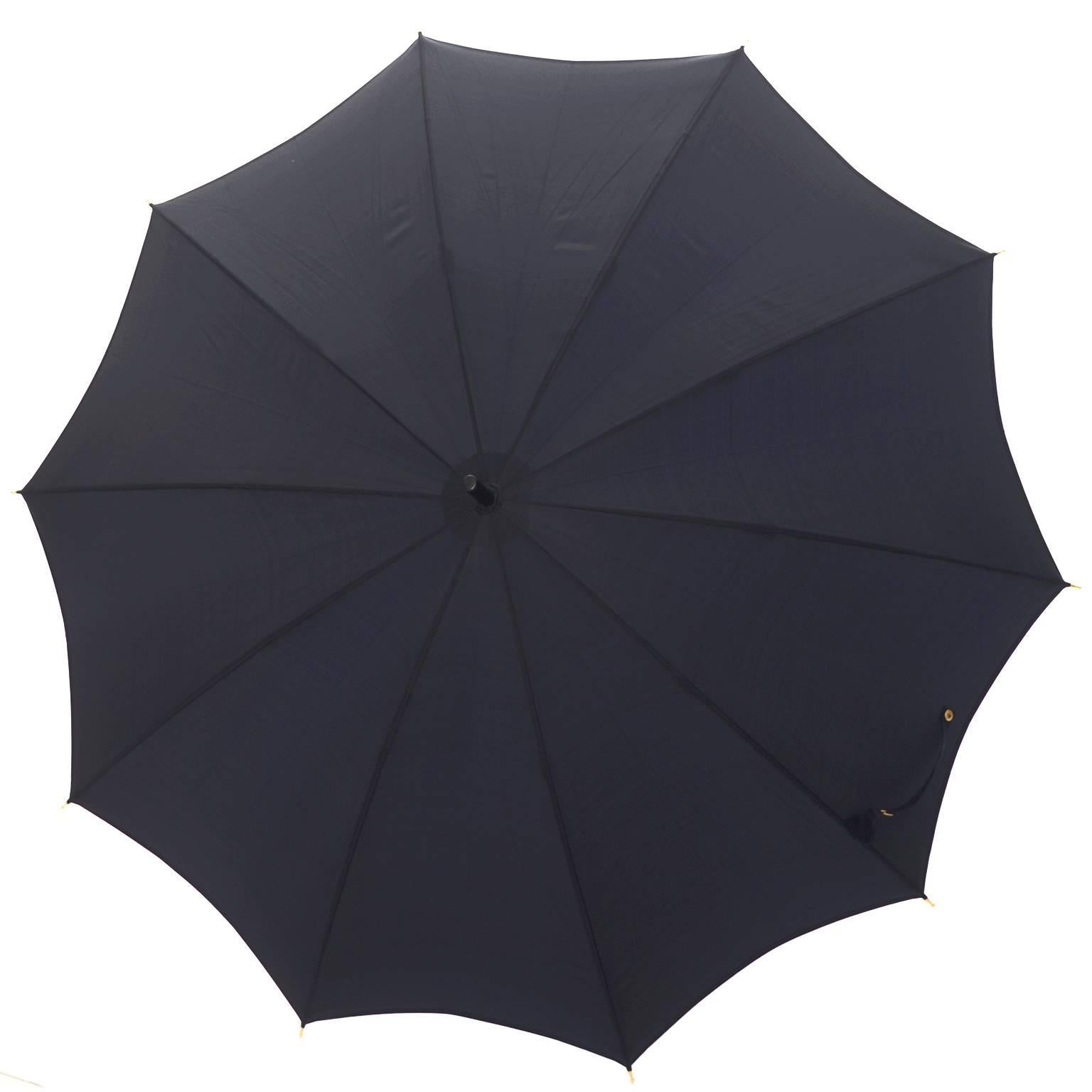 This is a black, classic, timeless Gucci vintage umbrella that is in as new condition with its original fabric sleeve.  The umbrella has the white and gold Gucci label inside, and it measures 33 inches wide and 27 inches from the top of the umbrella