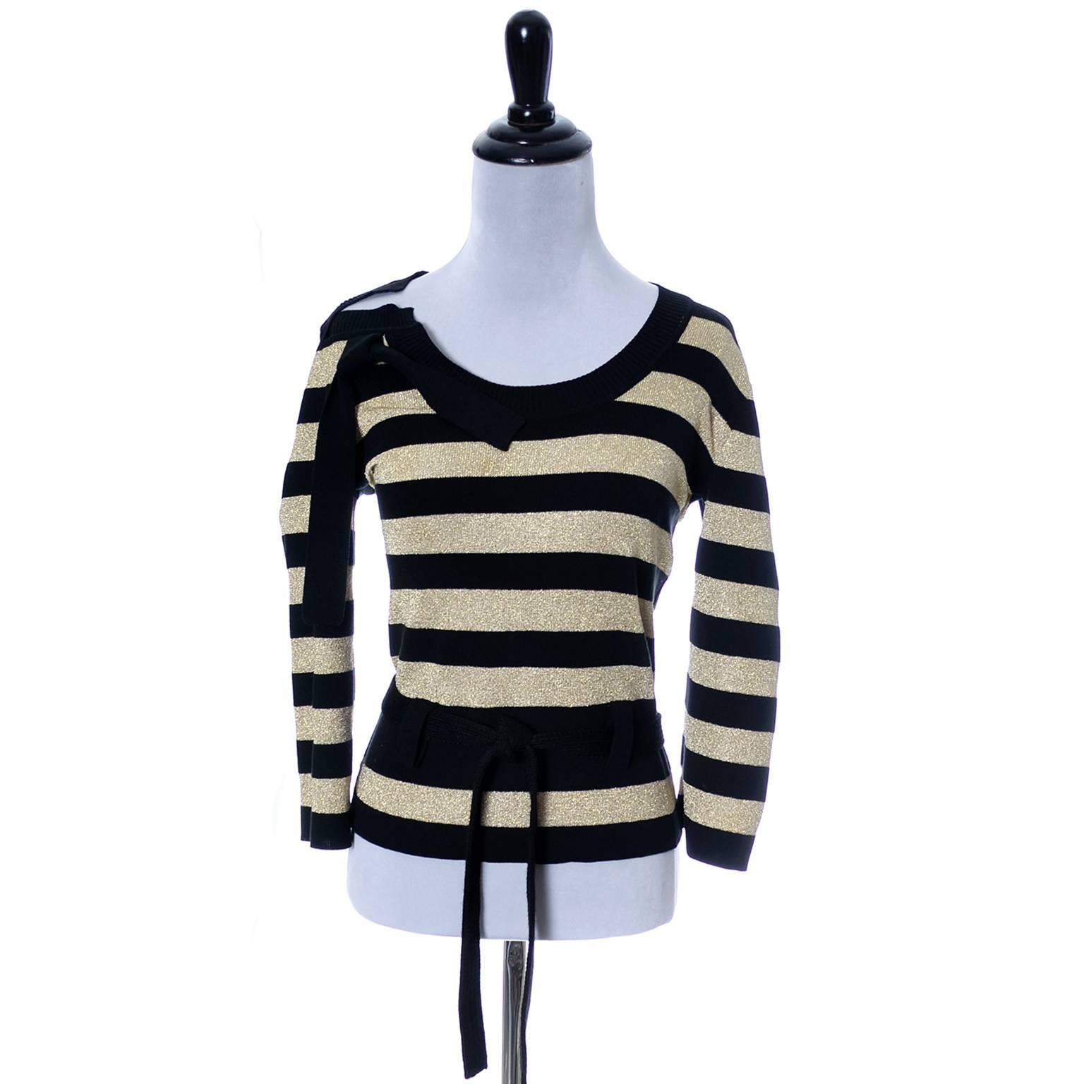 This is a great vintage top in as new condition from Sonia Rykiel from the 1980's.  This pretty sweater has alternating stripes of black knit and gold sparkle knit, a knit belt and a pretty knit bow at the shoulder. The fabric is a blend of cotton,