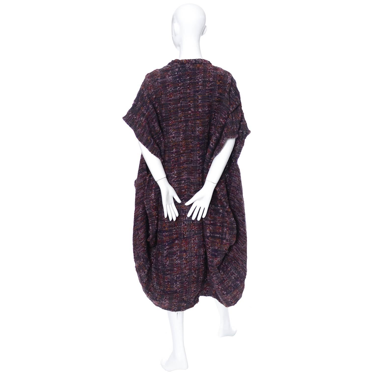 This vintage set consists of 2 beautiful hand woven pieces designed by Nikos in the 1980's.  There is an over-sized vest (or sleeveless sweater) and a matching shawl style scarf.  The fabric is purple and burgundy wool, woven with beautiful black