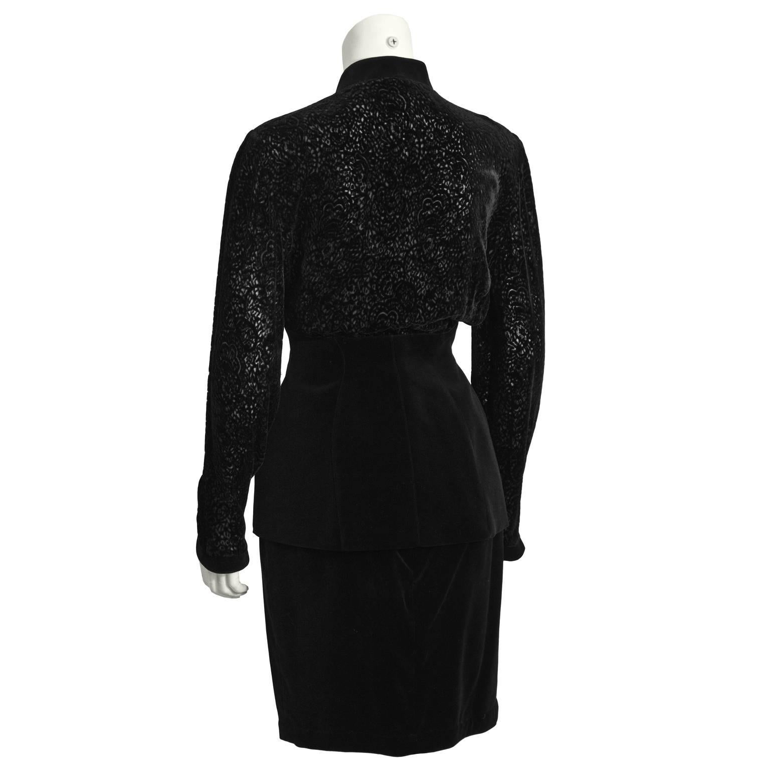 This fabulous and unique Thierry Mugler black velvet skirt suit dates from the 1980's. Jacket features a loose fitting flocked velvet bodice, with a cinched corset waist, and a front snap button closure. Black velvet pencil skirt has two fixed