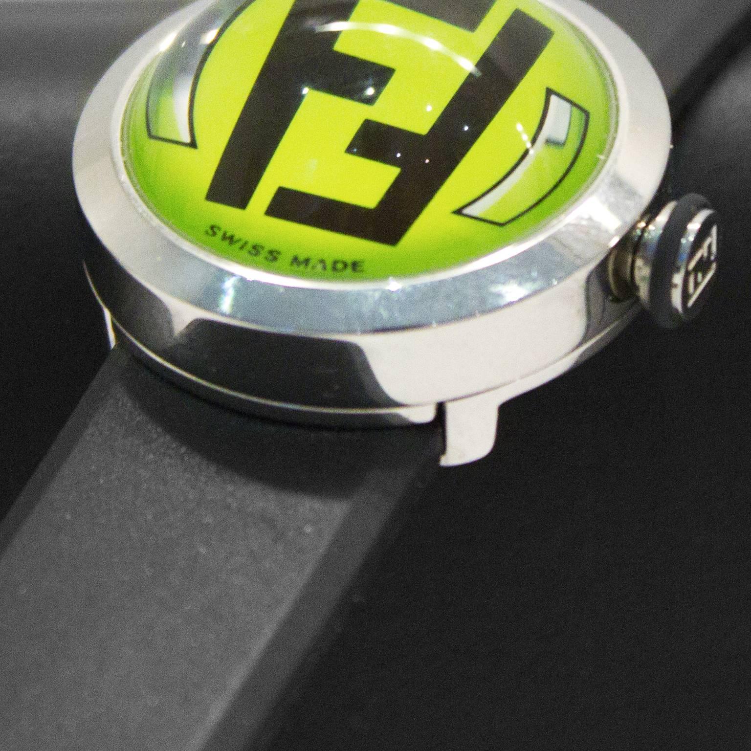 Hard to find Fendi bubble watch from the 1980's featuring a stainless steel frame, a dome crystal over a green face, the Fendi monogram on the center, and a black silicone rubber band. Day and date features on the sides are very futuristic.