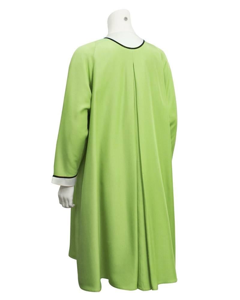 1960's Geoffrey Beene swing style slubbed silk  coatdress. White collar, cuffs and pockets accented with black piping makes this fresh green colored dress more formal. Buttons open at the collar and roomy pockets can hold a few necessities. In