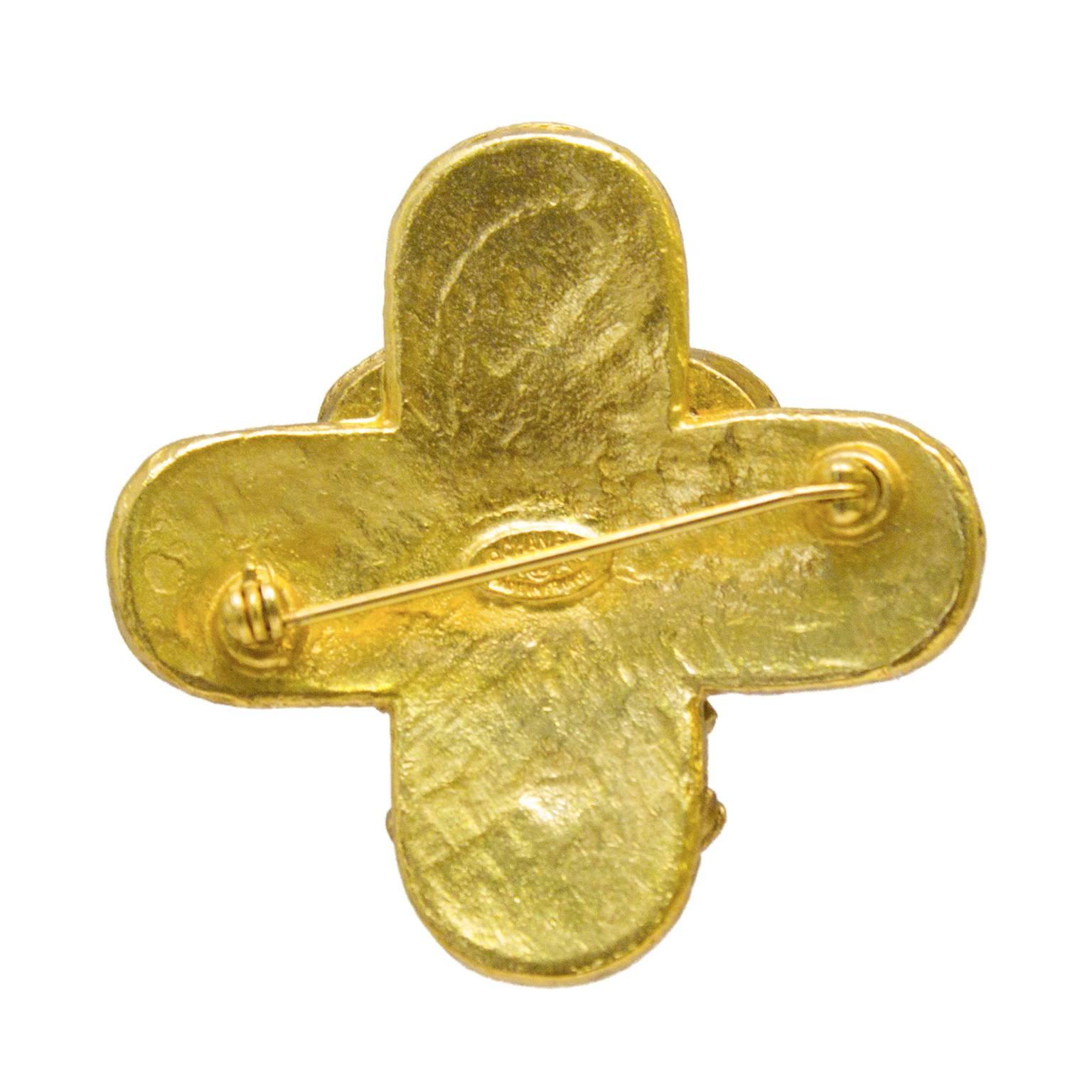 Chanel cross-shaped pin from the 1994 Fall collection. The goldtone pin features three CCs at the center of the cross with a rope and ball detailing along the edges. In excellent condition, closes with a C clasp on the back. 