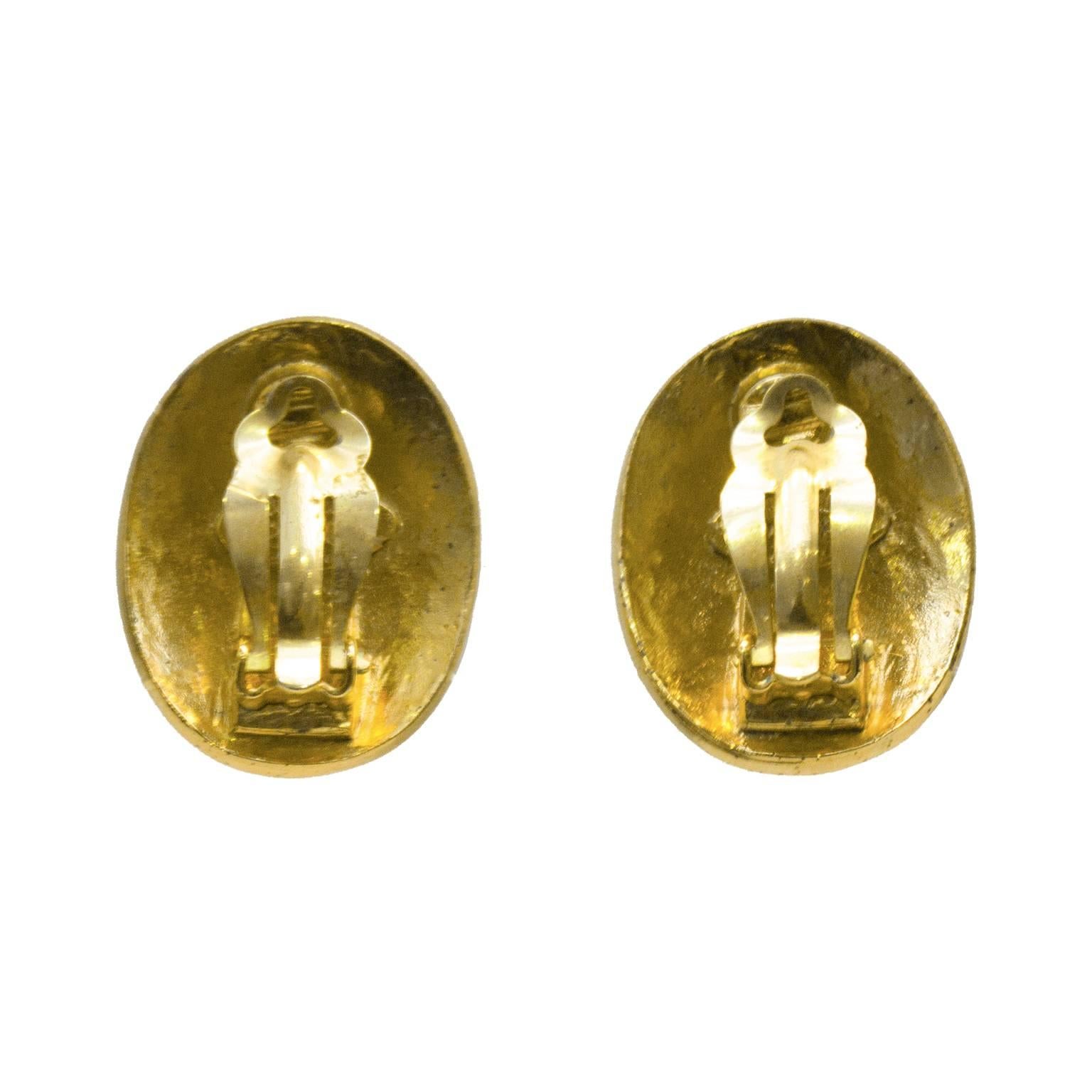 Chanel oval clip on earrings from the 1991 collection. The earrings feature a CC stamped at the center with a raised border. CHANEL PARIS is stamped along the border with tiny stars at the top and bottom. Stamped Collection 28, in excellent