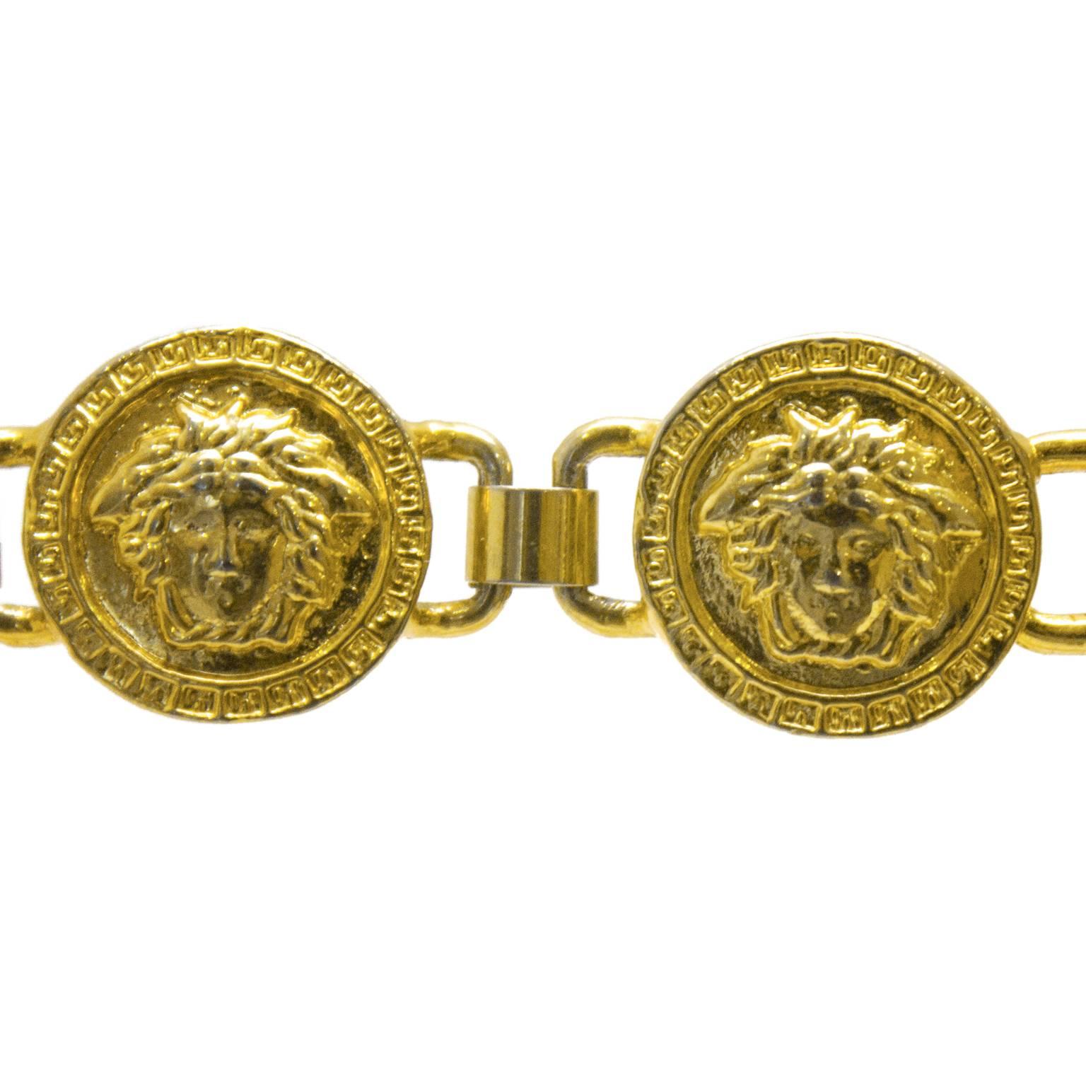 Versace goldtone link bracelet from the mid 1980’s. The coin charms feature the iconic Versace lion’s head with a Greek key border connected with square links. Closes with a fold over style clasp. Signed GIANNI VERSACE MADE IN ITALY under one of the